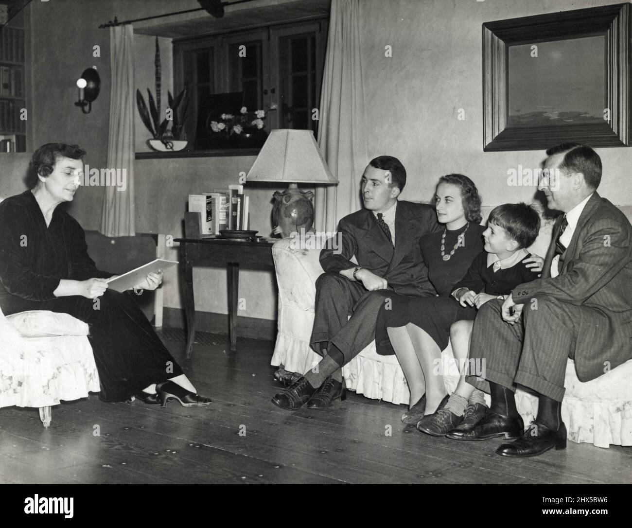 A Family Campaign Conference -- Mrs. Madeleine Sloane, daughter of the late Thomas A. Edison, is shown Sept, 2 in her home at West Orange, N.J., as she read a campaign speech to her family after launching her candidacy for the republican Congressional Nomination form New Jersey's 11th district. Seated opposite her (L to R) Are her son, Thomas Edison Sloane; Mrs. Thomas Edison Sloane; Michael Edison Sloane, Another Son; and John Eyre Sloane, her husband who is a New York investment Banker. March 9, 1938. (Photo by Associated Press Photo). Stock Photo