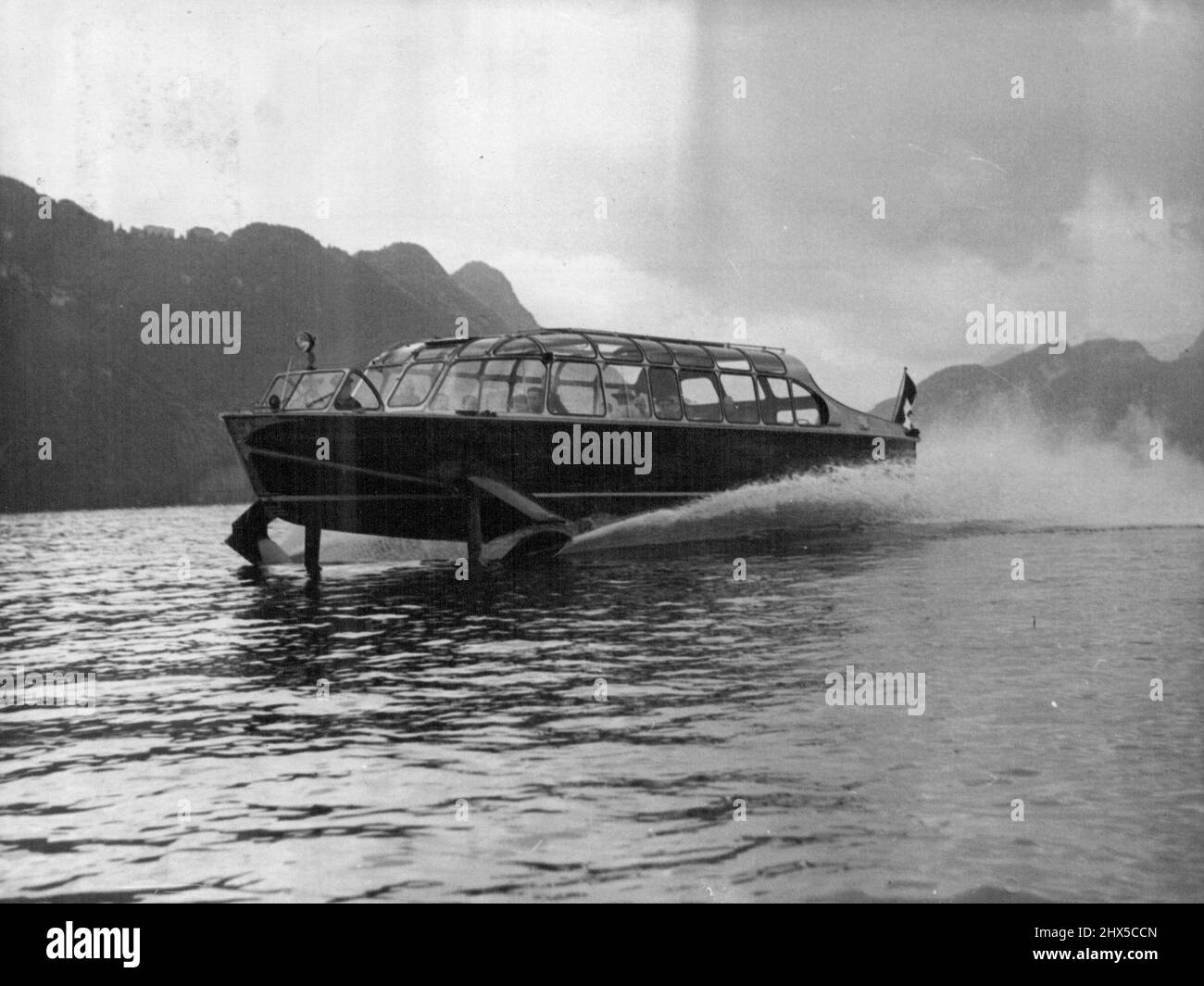 World' s Fastest Passenger Boat -- The Hydrofoil craft at speed during a demonstration run. Claimed by its inventor, Hans Von Schertel of Germany, to be the fastest passenger-carrying boat in the world, a 45-foot-long boat with wings was put through its paces on lake Lucerne, Switzerland, September 9. It covered 50 miles up and down the lake at 50 miles an hour with 32 passengers aboard. The Hydraulically-operated 'Wings' lifted the main part of the craft out of the water shortly after it started, decreasing the water-drag by some 50%. The craft is powered by a 350HP diesel engine driving a no Stock Photo