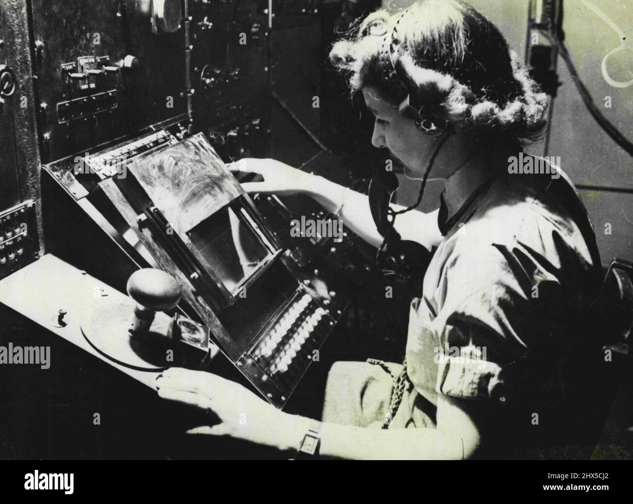 W.A.A.F. Radar Workers -- An airwoman plotting aircraft on the Cathode-Ray tube. Working under the closet secrecy since 1939, over 4,000 W.A.A.F. personnel have played an important part in the air victories achieved by radiolocation. They have tracked hostile and friendly aircraft, flying bombs and rockets, German E-boats and Allied Merchant vessels and have guided British and Allied fighter pilots on to enemy aircraft. Trained to use and service some of the most delicate and complicated instruments ever invented, they have carried out their duties with enthusiasm, often under uncomfortable Stock Photo