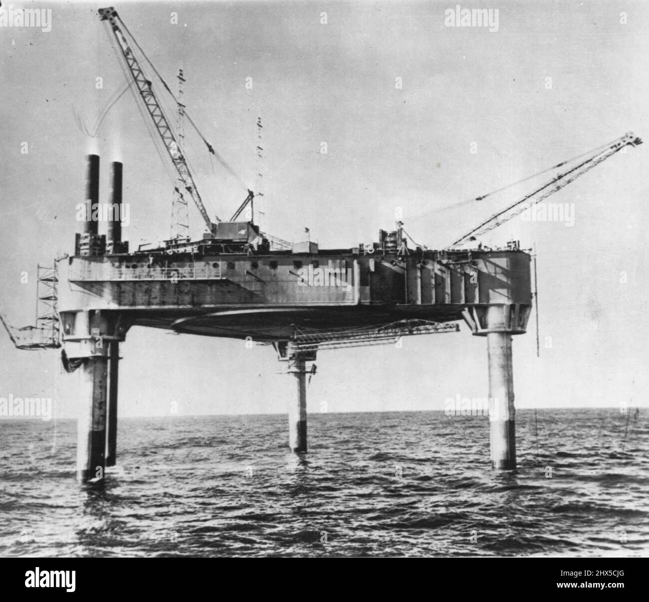 Lashed By Storm -- The Texas Tower, first of a series of early warning radar stations to guard the Atlantic coast, is being lashed today by a storm of hurricane violence. So far there have been no casualties among the 87 persons aboard. Reports have been received via marine telephone from AP staffer Don Guy, who, with a group of Air Force and civilian technicians, have been marooned atop it since Thursday. This picture of the structure was taken at its permanent location 110 miles off Massachusetts earlier this month. November 20, 1955. (Photo by AP Wirephoto). Stock Photo