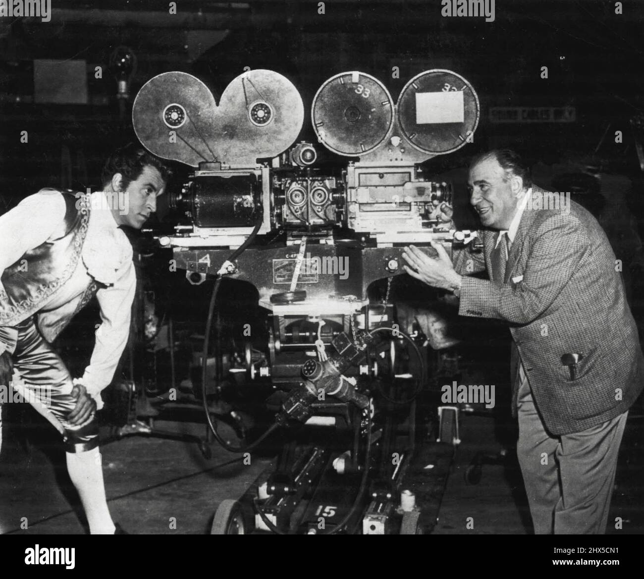 New - Dimensional Revolution Hits Hollywood - The swift rise of television in public favor has forced the movie industry into a revolution as sweeping as the advent of sound 25 years ago--the production of films with three-dimensional effects. Here Actor Fernando Lamas and Director Edward Ludwig inspect the three-dimensional cameras being used to photograph 'Sangaree' in Paramount's new 3-D process cal led Paravision. Special glasses are needed to view the finished product. February 9, 1953. (Photo by AP Wirephoto). Stock Photo