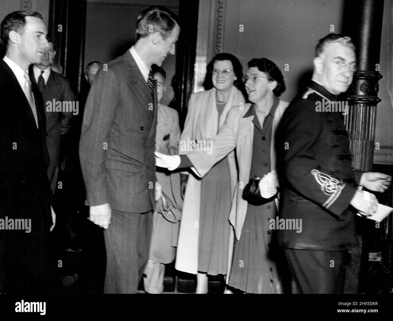Flashing his now famous smile, Sir Edmund Hillary, of Mount Everest fame, is greeted by Mrs. I.I.Reynolds, who claims she is a cousin of Sir Edmund's, at the civic reception given in his honor at the Sydney Town Hall today. August 5, 1953. (Photo by Associated Newspapers Ltd.). Stock Photo