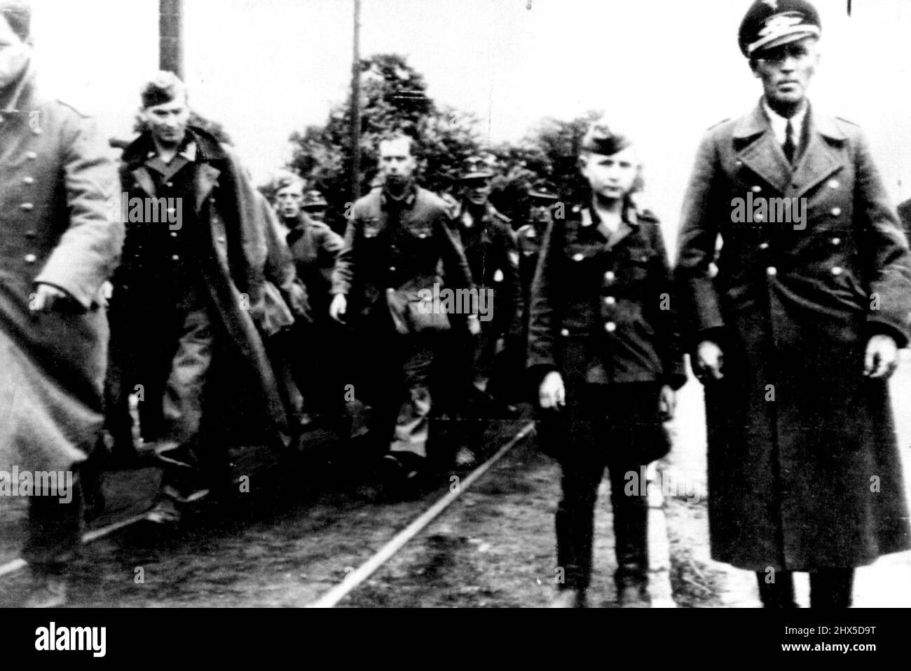 10-Year-Old Among Antwerp Prisoners This ten-year-old but standing beside his Major, was among German Prisoners captured at Antwerp, Belgium, by advancing Allies. Other German Prisoners file past at left. September 8, 1944. (Photo by Associated Press Radiophoto). Stock Photo