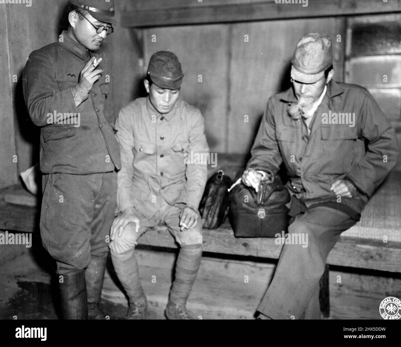 War Criminal -- Dr. Hisakichi Tokuda, allegedly responsible for medical experimentation on American POWs, shown talking with two Jap soldiers, while waiting to be transferred to the Omori Prison to await trial. November 10, 1945. (Photo by US Signal Corps Photo). Stock Photo