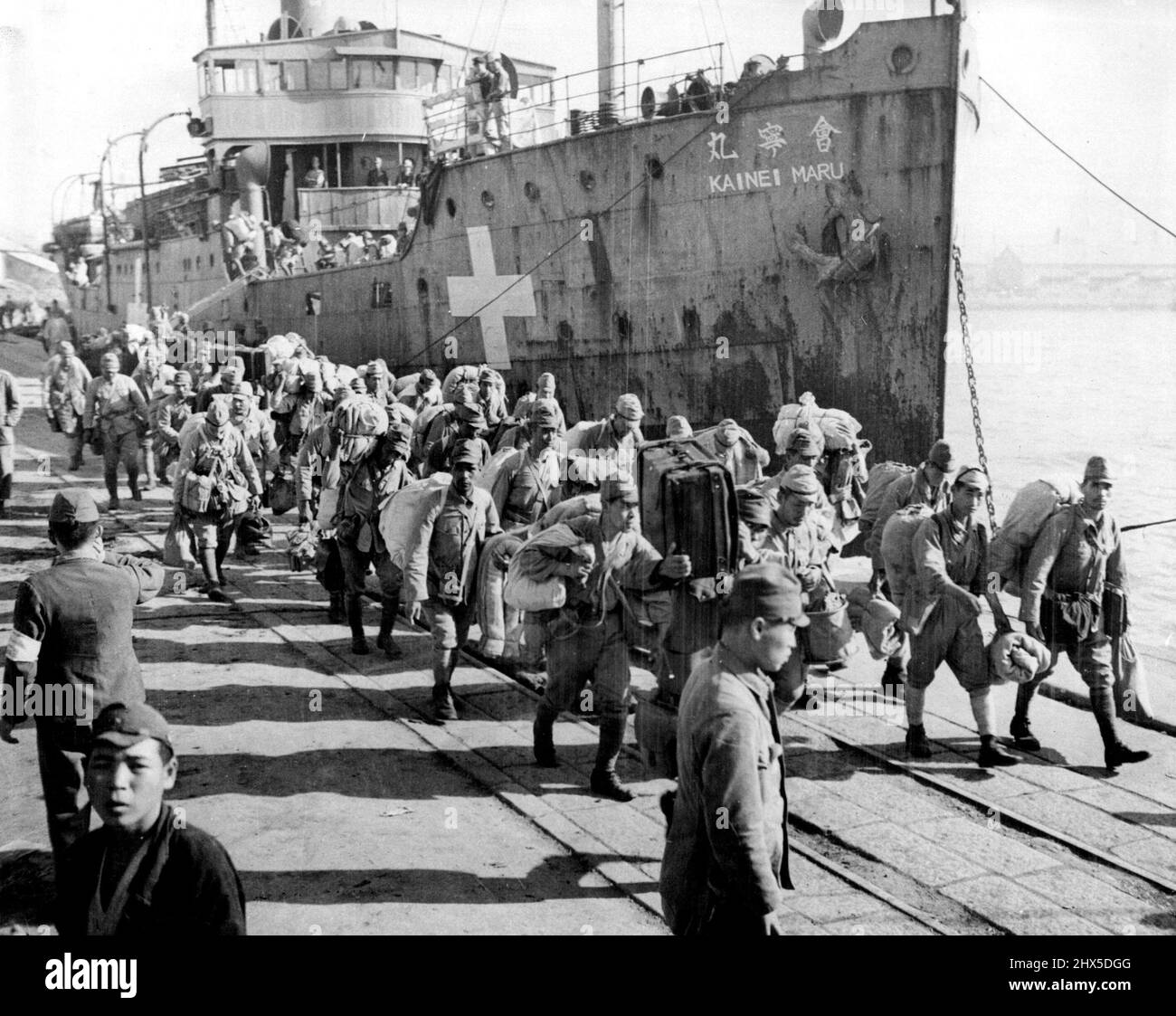 Japanese Troops Return from Korea -- After leaving the ship 'Kainei Maru' which has brought them from Korea, Japanese troops are shown marching along dock enroute to Darwin at Hakata, Fukuoka Perfecture, Hyushu, Japan, which will take demobilized men. October 21, 1945. (Photo by U.S. Army Photo). Stock Photo