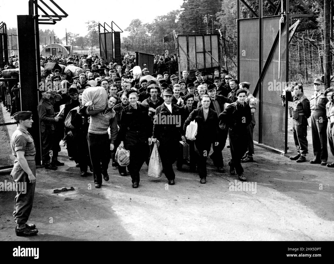 Leaving the Barbed wire behind Them : The first batch of German P.O.Ws to be repatriated under the Government roth scheme will leave almost immediately for home. Here is a batch of them marching out from their camp at Colchester to entrain for the East Coast port from which they will sail to Germany. September 26, 1946. Stock Photo