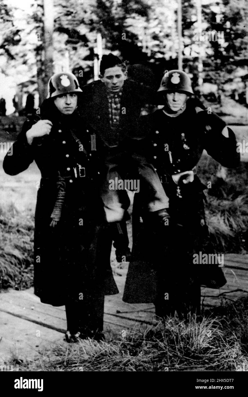 Ex-Prisoners Prefer Death To Germany! -- One of the German who refused to walk is carried to the train. They were destined for the Russian area. There were many cases of suicide and self-mutilation when the evacuation of German military refugees from Sweden commenced; they were going back to Germany as prisoners of war. Swedish policemen had to use their truncheons when, on being told that the transfer was to begin, the Germans began to stab themselves, and in some cases swallowed. December 31, 1945. Stock Photo