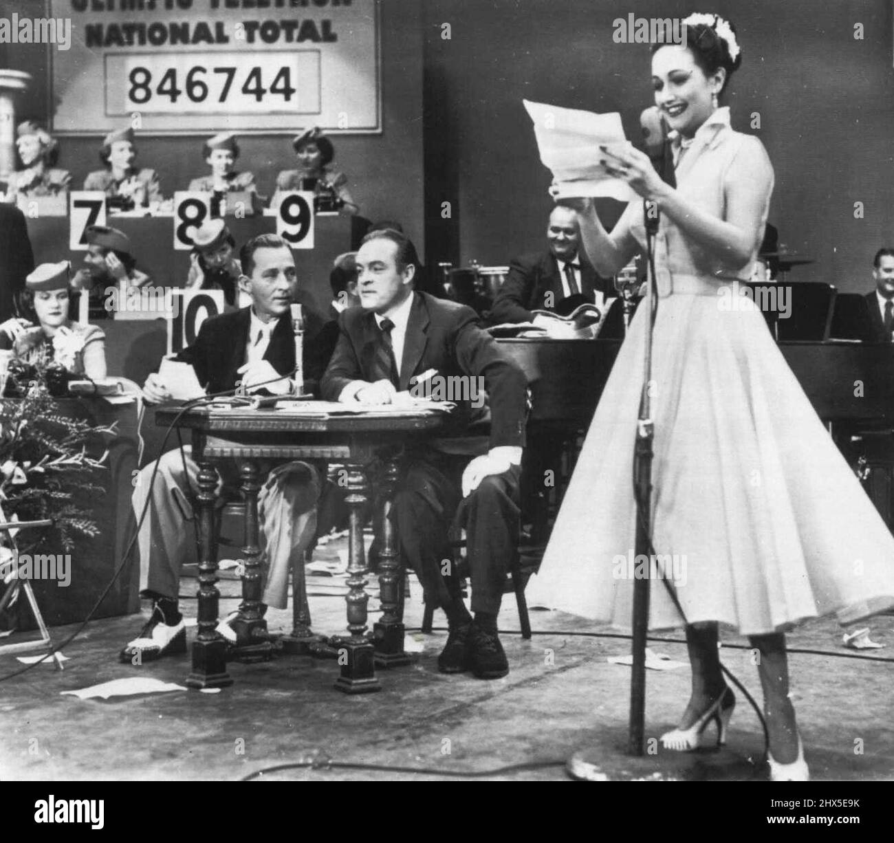 Bing Makes Television Debut--Bing Crosby (left) made his Long-awaited television debut teamed with Bob Hope to Co-emcee the 14 1/2 hour Olympic Telethon. The Coast to Coast TV show raised more than one Million Dollars for the U.S. Olympic Fund. Actress Dorothy Lamour, at right, aided the two in their Long Show. June 22, 1952. (Photo by AP Wirephoto) Stock Photo