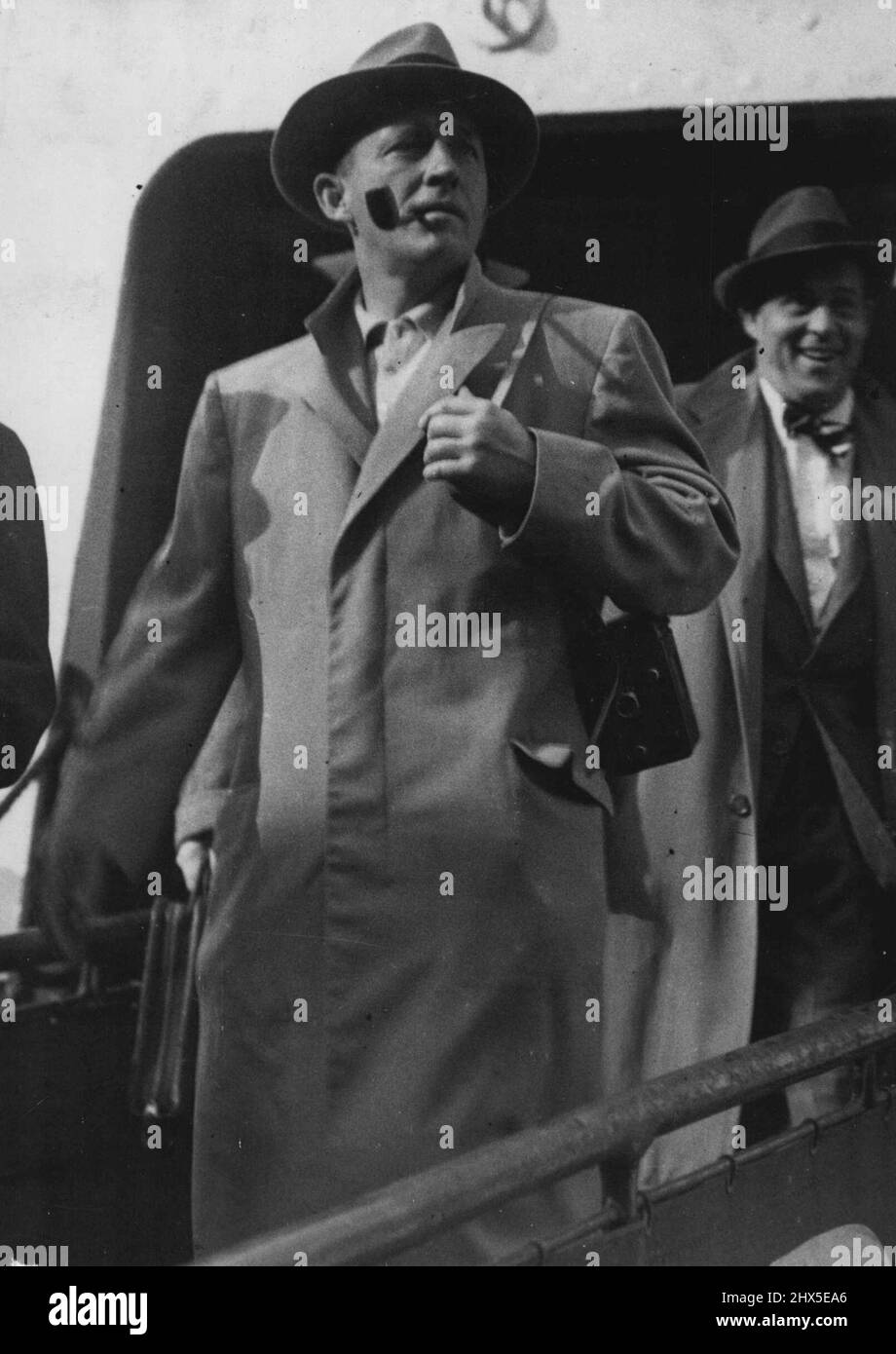 Crooner Crosby At Dover. Camera, Over his Shoulder Pipe in mouth, and a grin on his face, Bing Crosby arrives at Dover from the continent on his way to St. Andrews, Scotland,for the British Amateur Golf Championships Which open there tomorrow (Monday). On his arrival he was driven away in a car to a 'Secret' destination... Thousands of his 'Fans' who waited both at Dover and at London to See the Crooner were Unlucky. May 21, 1950. (Photo by Pictorial Department) Stock Photo