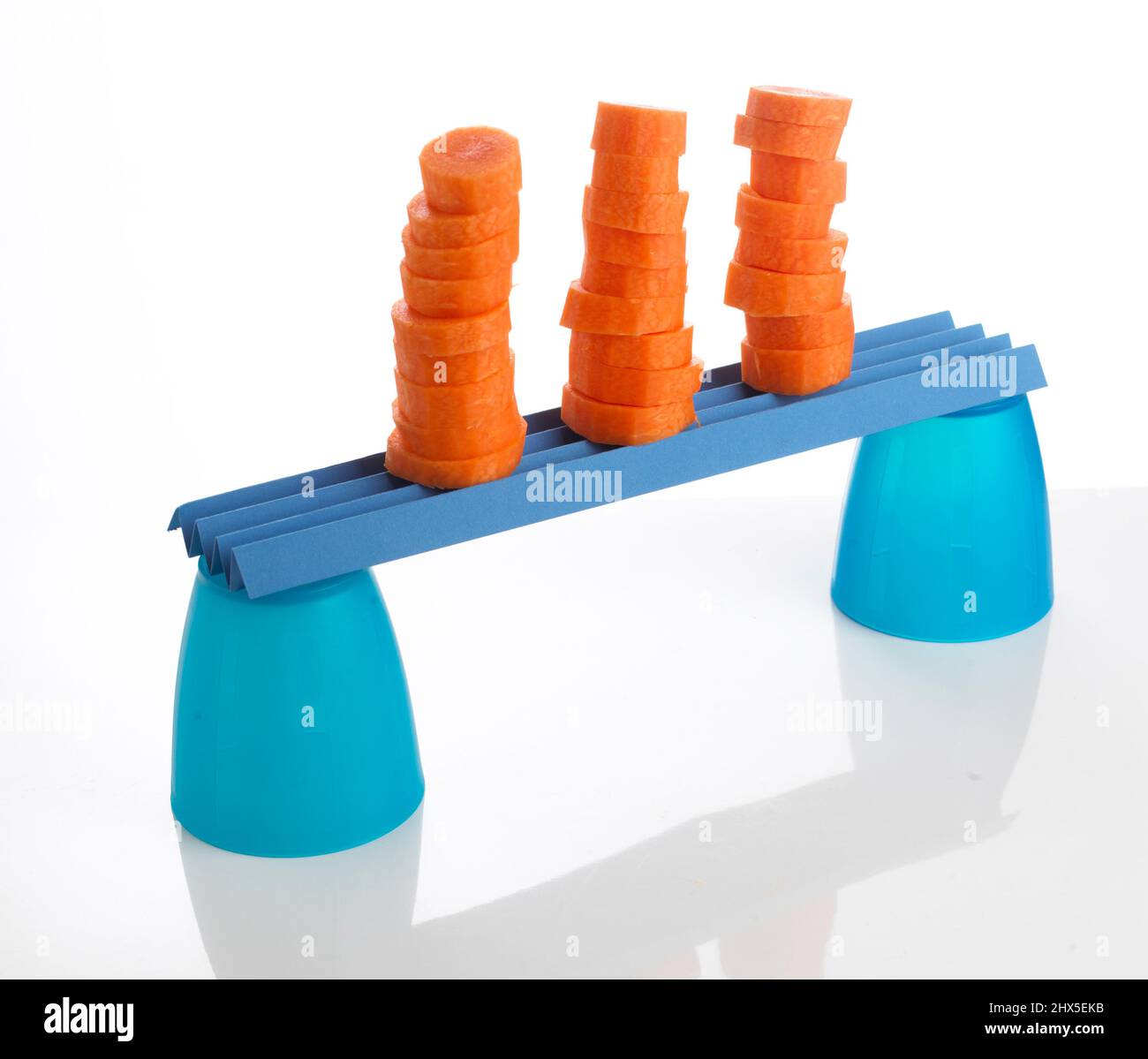 Stacks of chopped carrots balanced on plastic cups, close-up Stock Photo