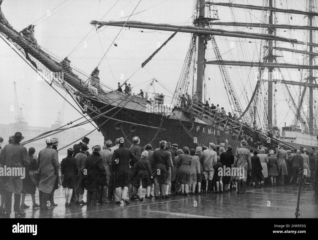 Londoners See The 'Pamir' The long queue waiting to go aboard the 'Pamir'. The four-masted barque 'Pamir' just arrived in London after her 80 day voyage from New Zealand, has now been thrown open to the public, and despite the bad weather, many hundreds of Londoners visited the famous sailing ship in the Victoria Dock. December 29, 1947. (Photo by Sport & General Press Agency, Limited). Stock Photo