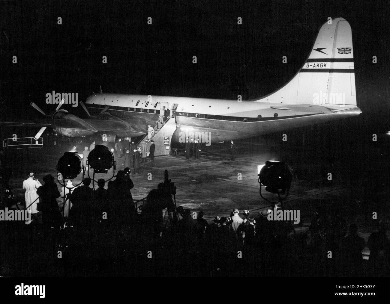 Royal Couple Off To Canada -- The Floodlights playing on the huge Canopus. In their glare the Queen, Followed by Princess Margaret, is seen walking down the Gangway. The goodbyes have been said. and a few minutes after this picture was taken the Royal Plane Took off. Scenes at London Airport last night when Princess Elizabeth and the Duke of Edinburgh were boarding the Strato-Cruiser Canopus for their 3,400-mile flight to Canada. October 08, 1951. (Photo by Paul Popper). Stock Photo