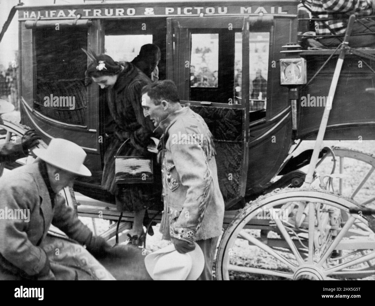 Arrive For Stampede -- Princess Elizabeth steps down from the stage coach which brought her, and the Duke of Edinburgh (Behind Princess), to the stampede (Rodeo) Festivities at Calgary, Alberta, October 18. The stage coach is the one used by King Edward VII when as a young man he visited Canada in 1860. October 21, 1951. (Photo by Associated Press Photo). Stock Photo