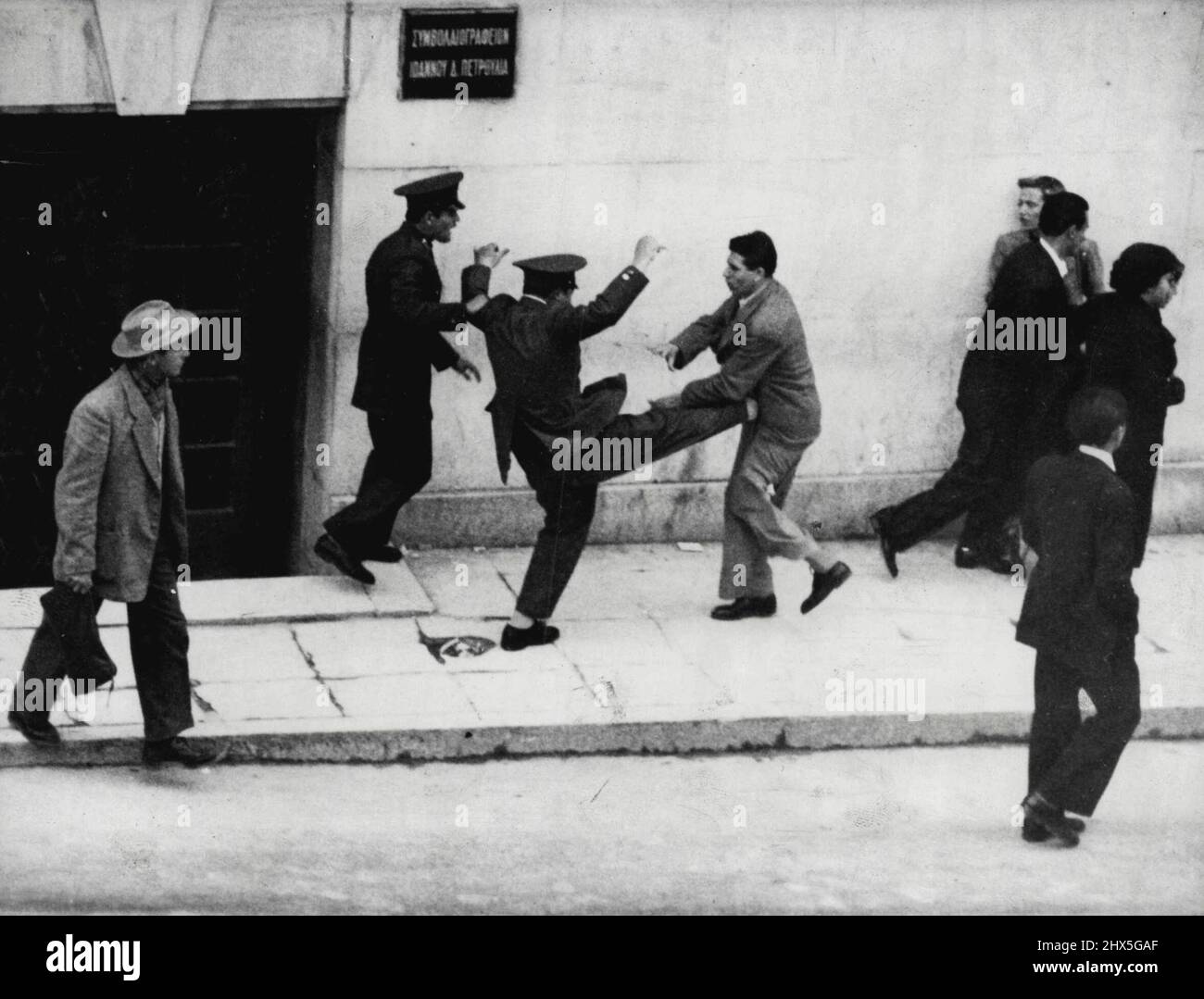 The sort of thing football talent scouts dream about. The photograph shows a Greek policeman in action in Athens the other day. Police some of them armed with clubs, broke up a demonstration by about 700 students who were agitating for 'Enosis' (Union between Greece and Cyprus). The police earlier, had banned the demonstration. April 21, 1955. (Photo by The Associated Press Ltd.). Stock Photo