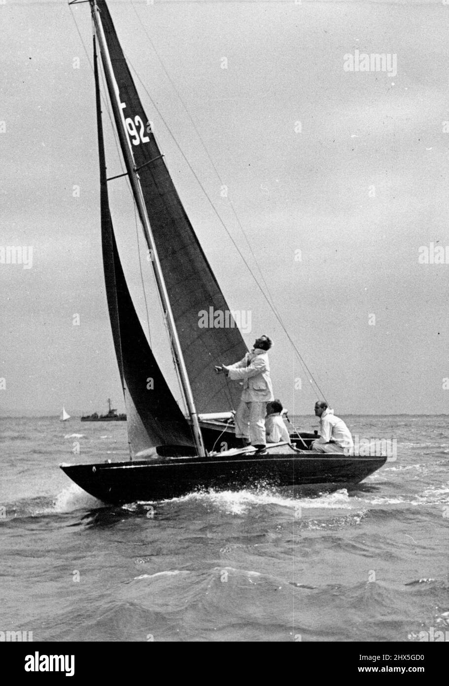 Duke of Edinburgh at the tiller of the Bluebottle. The Duke of Edinburgh retired from the Dragon-class race at Cowes Regatta yesterday after ten minutes. Bluebottle, the yacht be owns jointly with the Queen, was damaged in a collision, it is believed, with a motor launch. Her fore - stay was carried away and she returned to harbour with her main sail half-lowered. May 8, 1953. Stock Photo