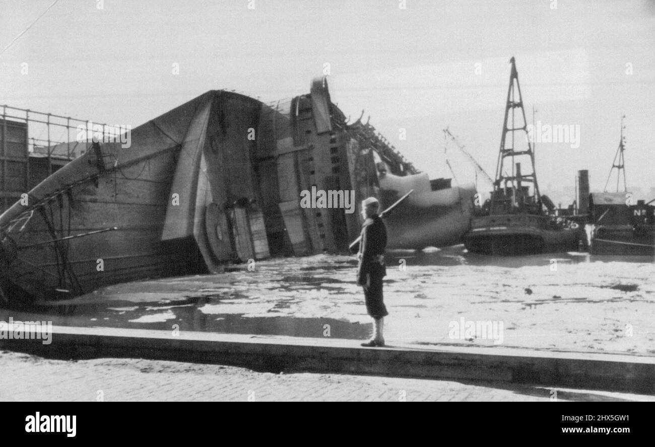 Normandie Quarded -- A U.S. sailor stands guard at one point of the pier slip where the Normandie lies on its side, victim of fire. Salvage tugs crowd about the liner -- renamed the Lafayette when the U.S. took it over. February 26, 1942. (Photo by AP Wirephoto).During World War II, Normandie was seized by U.S. authorities at New York and renamed USS Lafayette. In 1942, the liner caught fire while being converted to a troopship, capsized onto her port side and came to rest on the mud of the Hudson River at Pier 88 Stock Photo