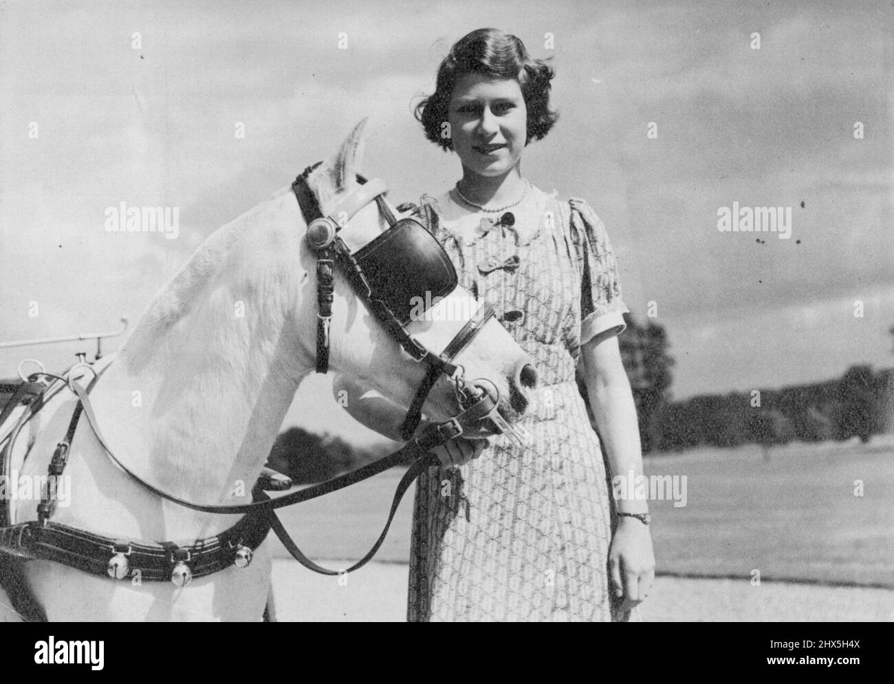 Princess In Their Wartime Home -- Picture taken yesterday of Princess Elizabeth and Princess Margaret in the garden of the country residence where they are staying during the War. This greatest pleasure is the occasional visits of the King and Queen. In view of the need for saving petrol their Royal Highnesses ponycart has again been brought into use. September 10, 1940. Stock Photo