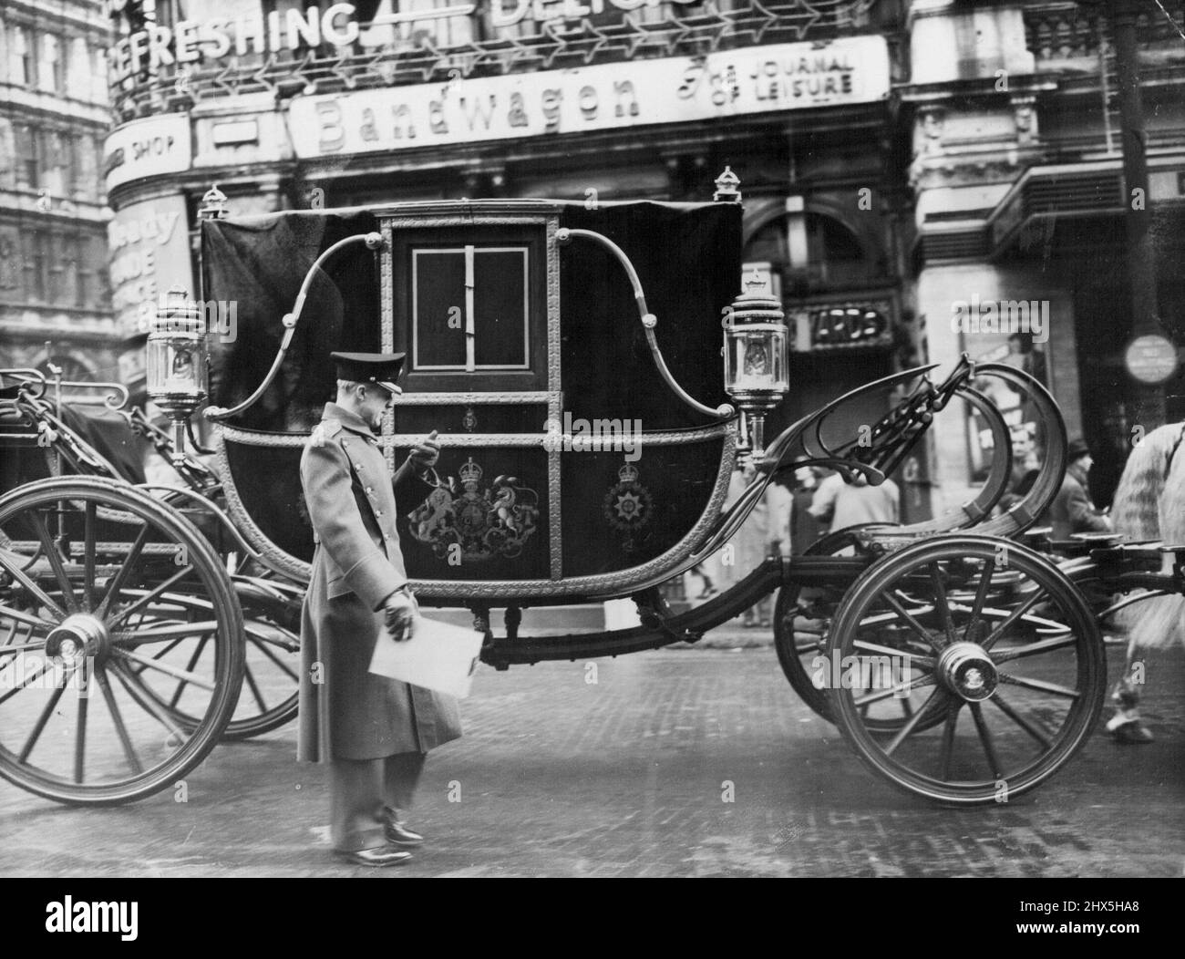 Coronation Procession Rehearsal a guards officer checks the time as the state landau leaves Piccadilly Circus and is about to turn into Haymarket. Guards officers and officials connected with the coronation procession arrangements timed a state landau drawn by eight Windsor Greys, a band, and detachments of guardsmen - over the second half of the coronation procession route this morning November 23 from 7:30am. Hoar frost lay on the roads, which had been specially cleared of traffic. November 23, 1952. (Photo by Associated Press Photo). Stock Photo