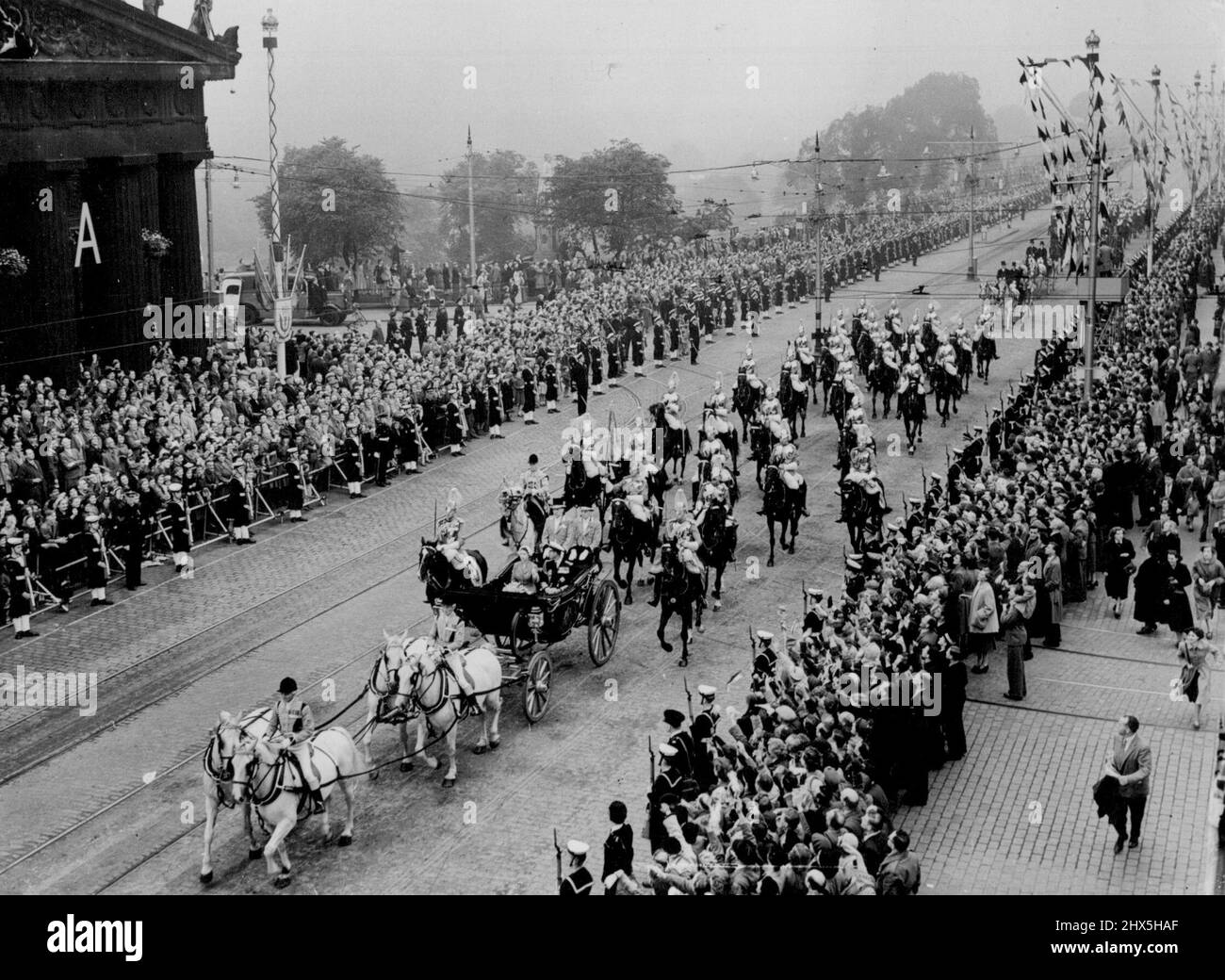 Queen and Duke in Edinburgh. The Royal coach carrying the Queen and the Duke of Edinburgh passes in procession along Princes Street in front of the Royal Scottish Academy, shortly after, the Royal couple had arrived here for their Coronation State Visit to Scotland. June 24, 1953. Stock Photo
