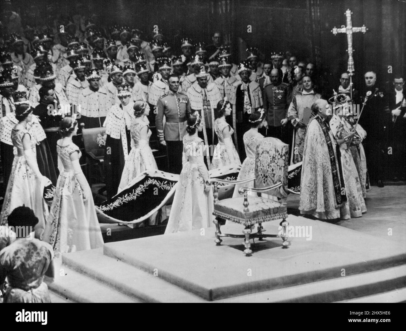 The Crowned Queen Leaves The Abbey -- The Queen, wearing the imperial state crown and carrying the sceptre with the cross and the Orb, leaves Westminster Abbey after her crowning to-day. Supporting her are the bishop of bath and well, Dr. Harold William Bradfield (right) and the bishop of Durham, Dr. Arthur Michael Ramsay. Six maids of Honour carry the Queen's train. Nearest the camera (right to left) Lady Mary Baillie-Hamilton; Lady Jane Heathcote-Drummond Willoughby; and Lady Rosemary Spencer-Churchhill. Farthest from Camera (Right to left) Lady Jane Vane-Tempest-Stewat; Lady Anne Coke; and Stock Photo