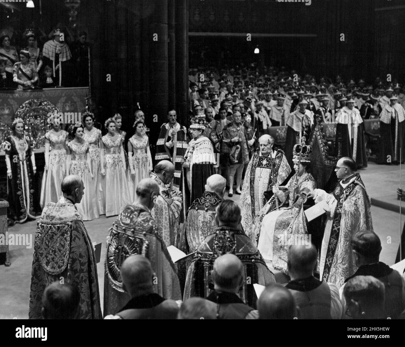 Our Queen is Crowned -- H.M. The Queen photographed immediately after the Crowning Ceremony, with St. Edward's Crown on her hear. Her Majesty is holding the Rod with Dove (of equity and mercy) in her left hand; and the Scepte with Cross (consign of kingly power and justice) in her right hand. The whole of the splendid gathering in the Abbey are now wearing their Coronets. June 02, 1953. (Photo by Press Photos Combine (Fox)). Stock Photo