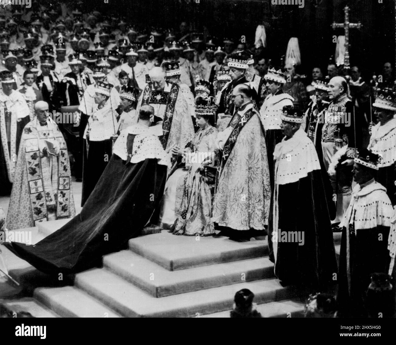 Duke Pays Homage To His Wife, The Queen - The Duke of Edinburgh kneels before the throne and pays hoamge to his wife Queen Elizabeth II, in Westminster Abbey after her coronation yesterday. Churchman at left, holding book, is the Archbishop of Canterbury. Flanking the Queen are the Bishop of Durham, left, and the Bishop of Bath and Wells. Others surrounding throne are unidentified peers and churchmen. June 03, 1953. (AP Wirephoto). Stock Photo