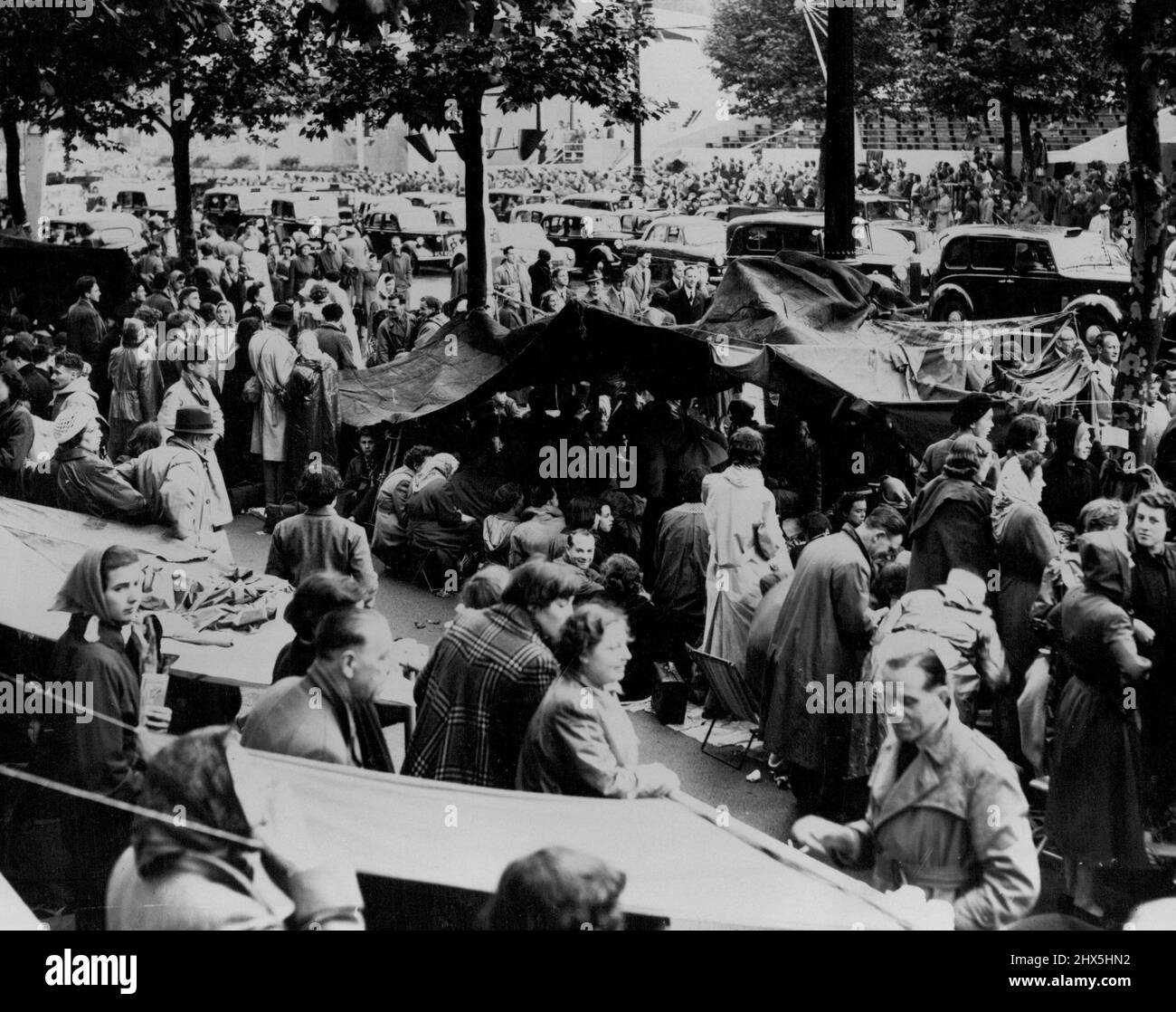 Tent Town Springs Up In The Mall Van -- A view of a section of the Mall this afternoon, during the heavy rain which threatened to drench the crowds taking up early positions to watch the Coronation procession. They were ready however, and soon the Mall became a mass of tarpaulin tents. June 01, 1953. (Photo by Fox Photos). Stock Photo