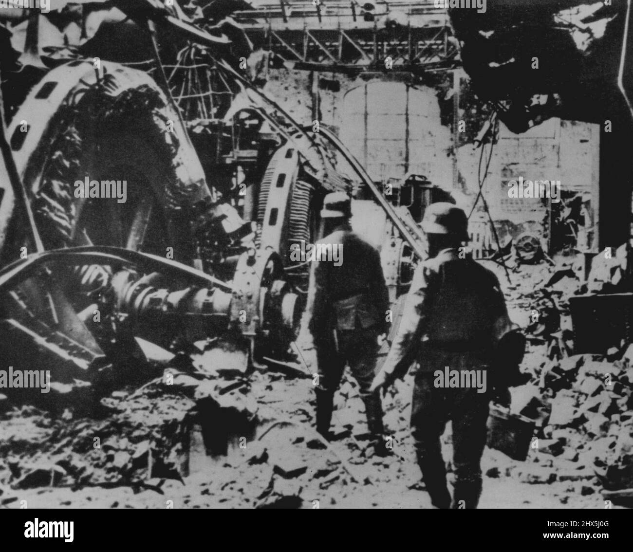 Nazis Inspect Stalingrad Damage -- German soldiers examine wrecked German made generators in a damaged Stalingrad power plant according to the German captions accompanying this picture which arrived here today from Lisbon. January 9, 1943. (Photo by AP Wirephoto). Stock Photo