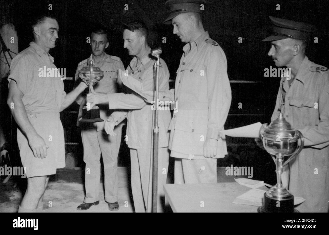 ***** is presented to LAC J. Brander, R.A.A.F. who won the light-heavyweight division on a TKO in the first round. Not for publication before the afternoon of Wednesday 19.1.44. Combined Navy-Army-Air Force competitions were held in the North-western Area recently, when some vigorous bouts were fought. January 01, 1944. (Photo by Department of Air) Stock Photo