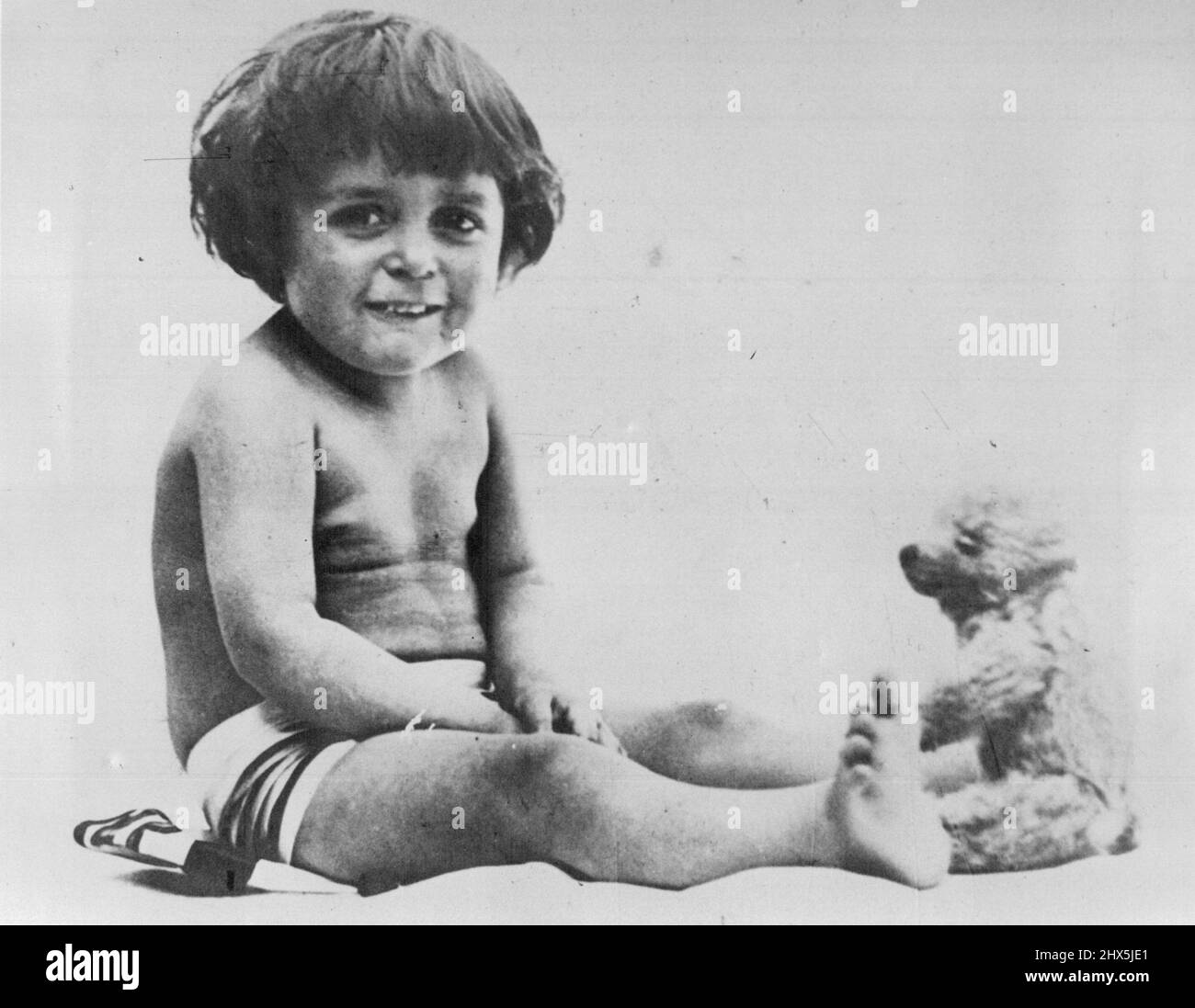 Not quite in the Shmith style, but just as appealing was this early shot taken of Shmith himself at about 18 months. The ribbon around his waist was intended to make him look like a kewpie doll. May 26, 1950. Stock Photo