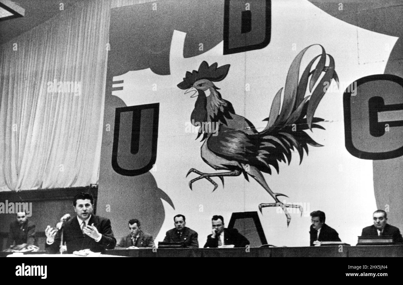 Pierre Poujade Addresses A U.D.C.A. Meeting -- Poujade, left, speaks during a rally organised by the Union for the Defence of Shopkeepers and Artisans in Paris. Behind the leader of the movement are his chief lieutenants; the backcloth depicts the Poujadists emblem an angry cockerel marching across France. February 28, 1955. (Photo by Camera Press). Stock Photo