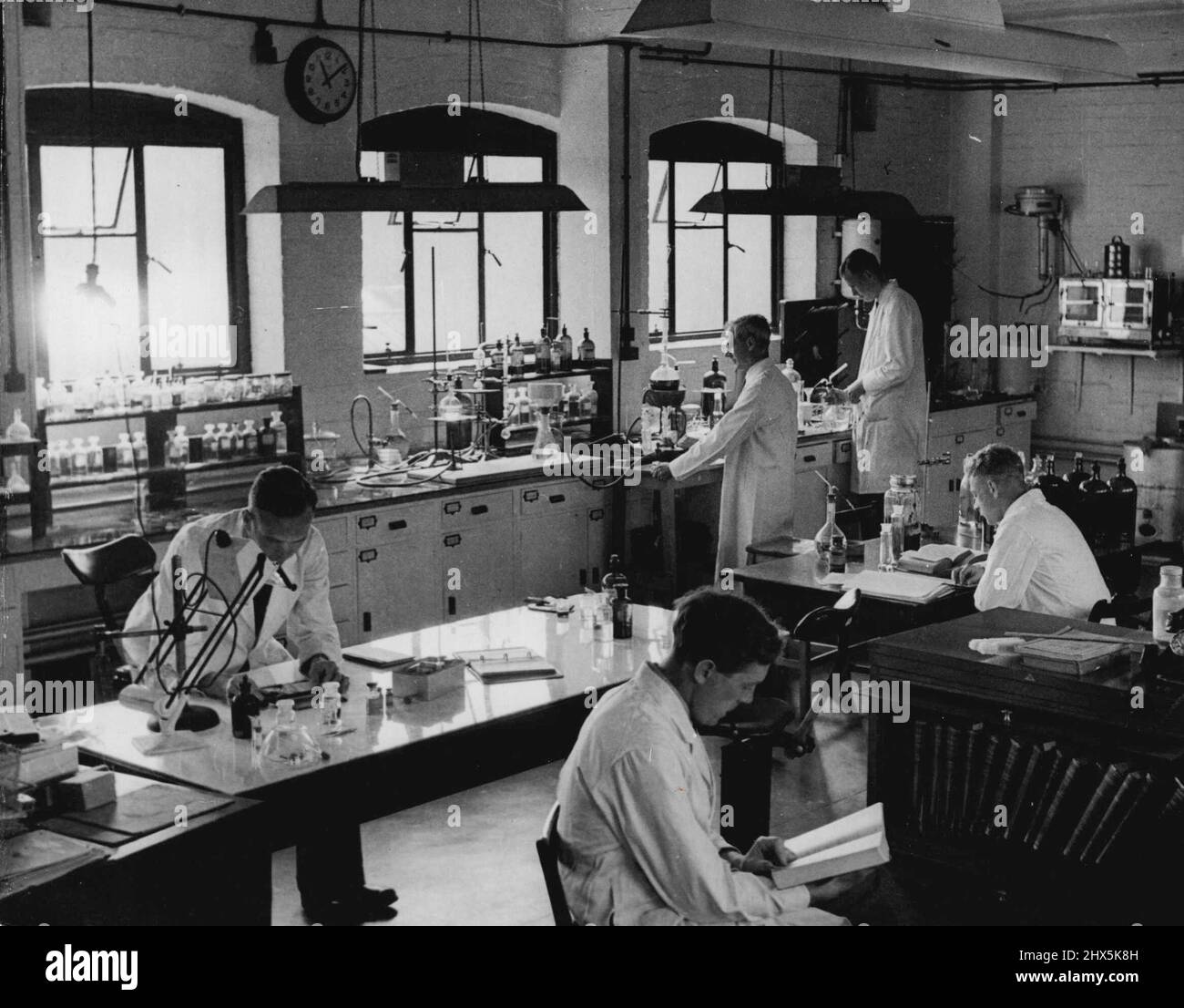 Science On The Side Of Justice -- A general view of the Chemical Laboratory of the Home Office S. Western Forensic Science Laboratory Bristol. In foreground (left to right) Police Lialson Office D/Inspector G. Mallett A.R.P.S., F.R.M.S., (at table) Mr. H.J. Walls, B.Sc. Ph. D. Senior Scientific Office and staff chemist (nearest camera) Experimental Officer B. Lilliman B.Sc. In background Experimental Officer H. Campbell (left) and Junior Assistant J.E. Fishbeck. December 29, 1947. (Photo by Topical Press). Stock Photo