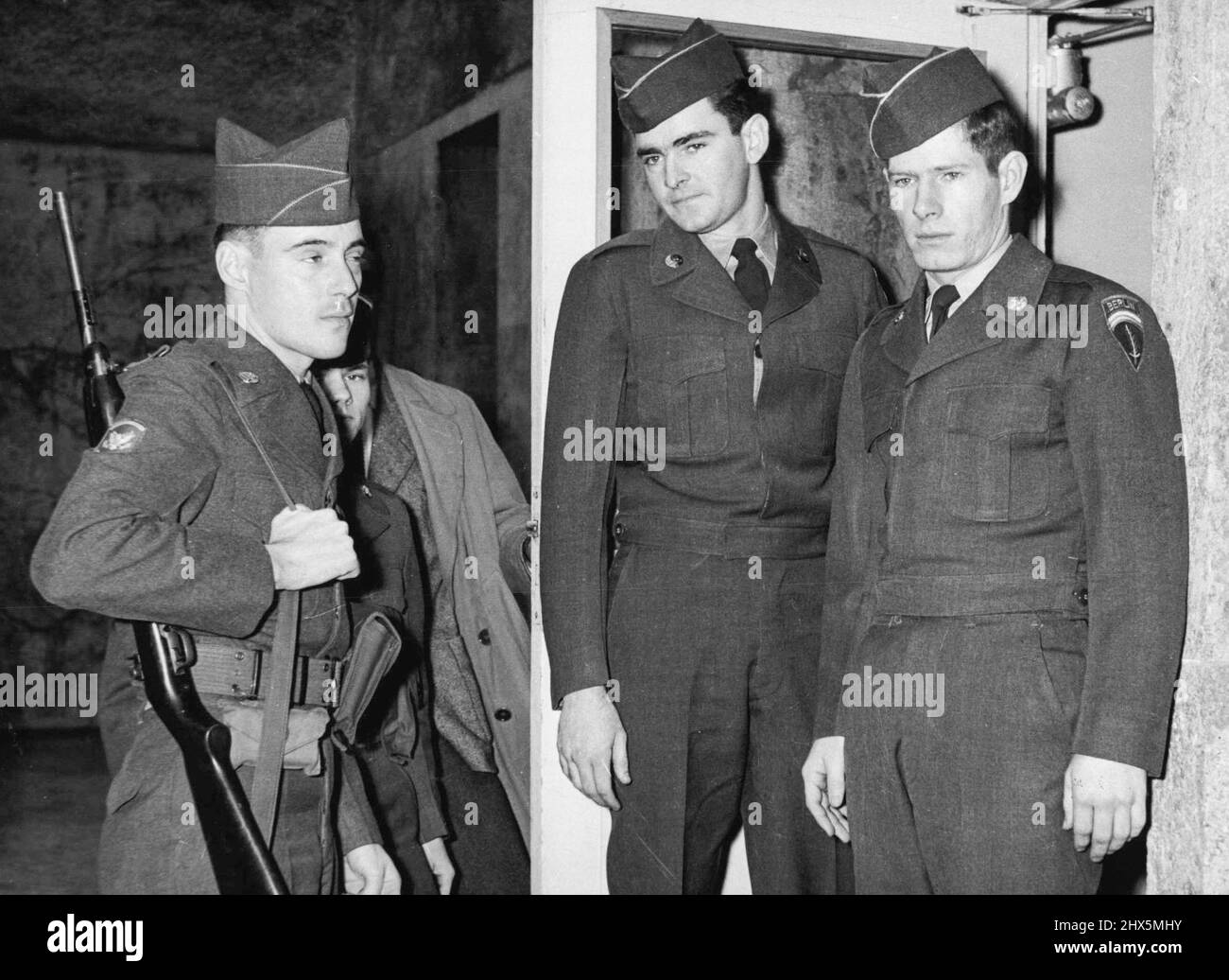 U.S. Soldiers Acquitted After Berlin Incident - Privates Holden and Calbert (left to right) with their escort on their arrival at U.S. Military headquarters in Berlin. Two American soldiers who were detained in East Berlin from December 6th to 10th after being involved in an incident with an East Berlin in Cabaret Artist, were Acquitted by a United States court martial in Berlin on Tuesday Dec. 19th. The accused, Private Holden and Calbert, both pleaded not guilty to disorderly behaviour 'Under Such Circumstances as to bring discredit upon the Armed Forces.' December 21, 1955. (Photo by Paul Stock Photo