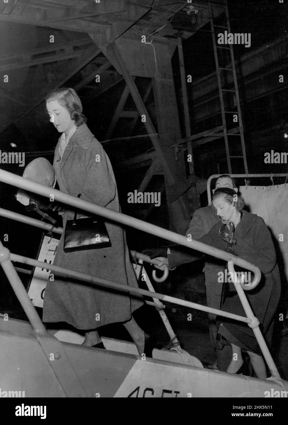 Boarding Royal Tour Liner - To Wish 'Bon Voyage' To Lord Althorp -- Lady Fermoy (carrying sword) follows her daughter, seventeen-year-old Miss Frances Roche, up the gangway to board the Royal tour liner Gothic at King George V Dock, London, this evening (Tuesday). They were going aboard to wish 'bon voyage' to Viscount Althorp (fiance of Miss Roche) who is Equerry to the Queen. Later the liner was leaving for Jamaica where the Queen and the Duke of Edinburgh will go aboard on November 27 for the start of the royal tour of Australia and New Zealand. The Gothic will take the royal party to the Stock Photo