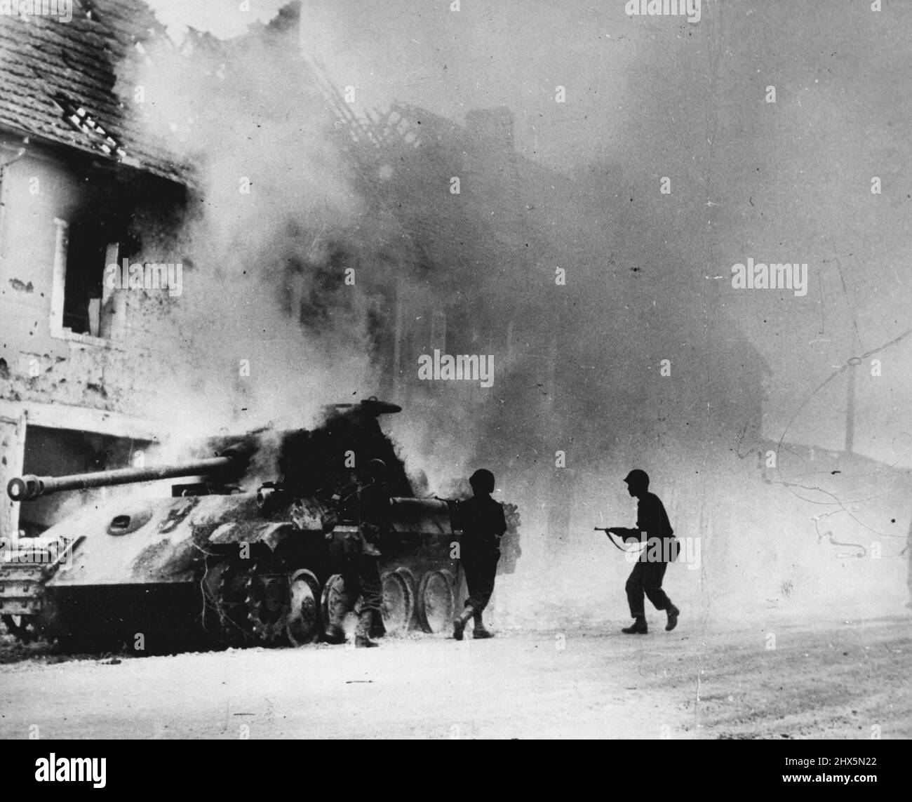 Nazi Tank Crippled in Battle in France: U.S. Troops surround a smoking tiger Mark VI, one of the largest of German tanks, after knocking out the armored vehicle on the Periers front. August 01, 1944. (Photo by U.S. Office of War Information Picture). Stock Photo