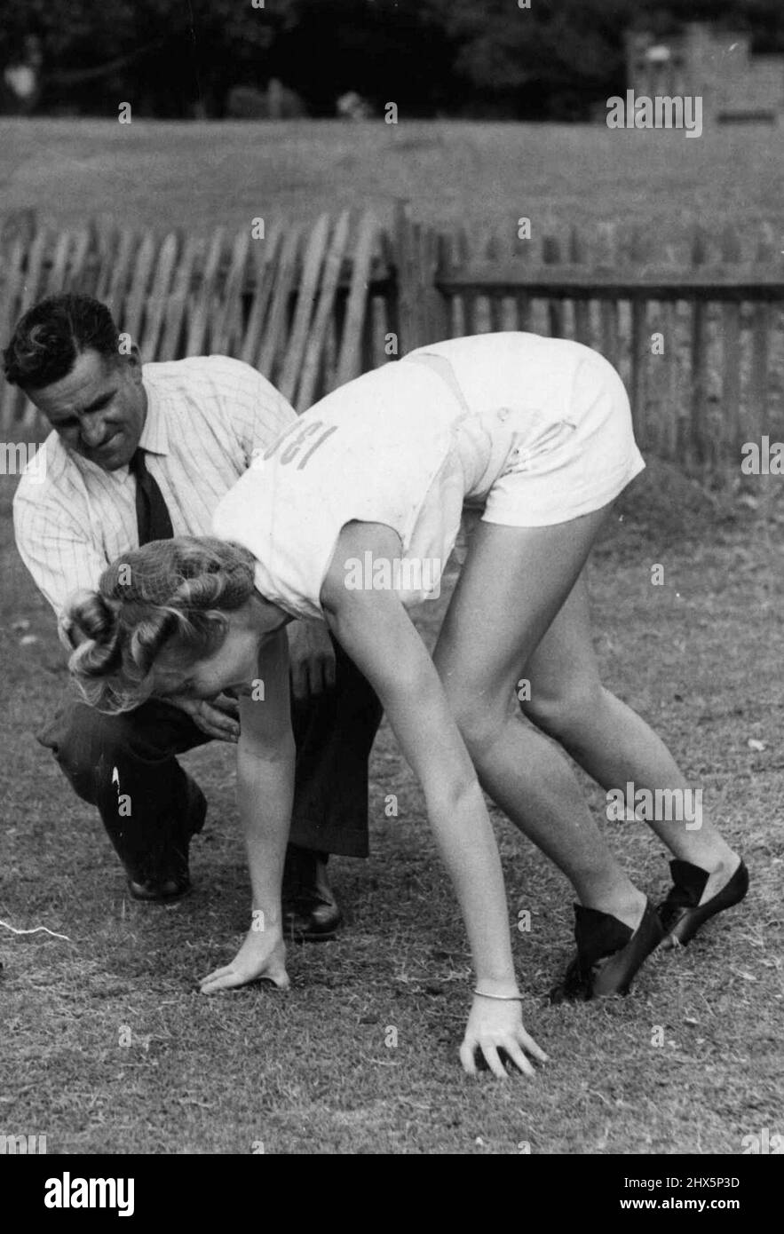 As a coach, he passed on all he knew about athletics to Shirley Strickland, who rewarded him by wining the Olympic 80 metres title. August 10, 1955. Stock Photo