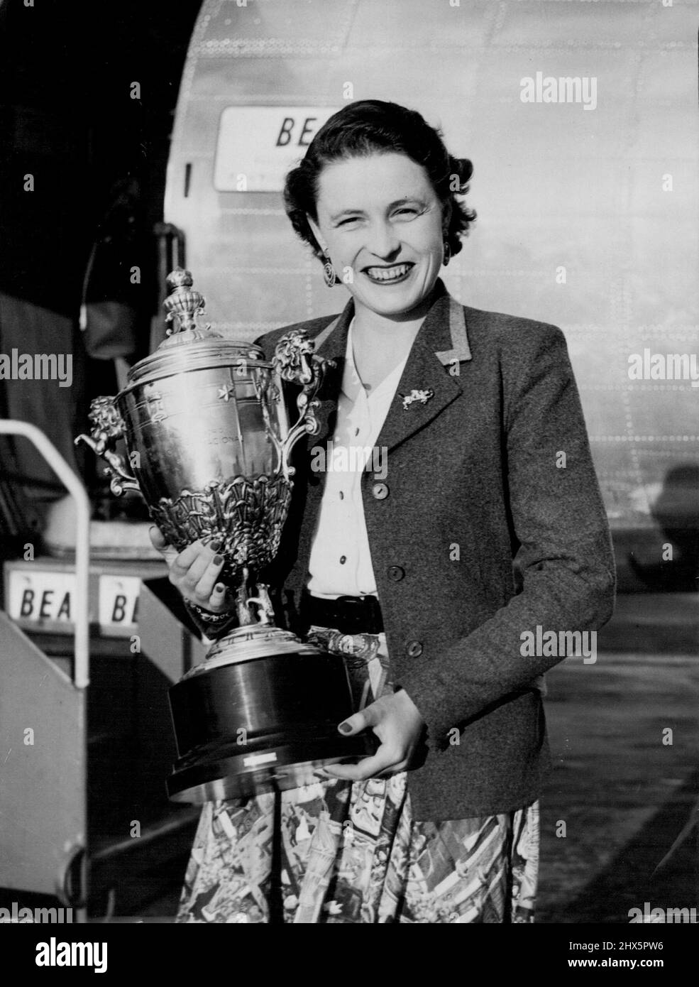 Another For Pat's Collection -- Clutching a massive cup she won at the International Horse show in Madrid, Miss Pat Smythe, Britain's leading horsewoman, is pictured at London Airport to-night (Monday) on her arrival from Paris by Bea Liner. Yesterday, Miss Smythe won the Prix de la Federation de Sports Equestres in the International Horse show at Vichy. July 05, 1954. (Photo by Reuter Photo). Stock Photo