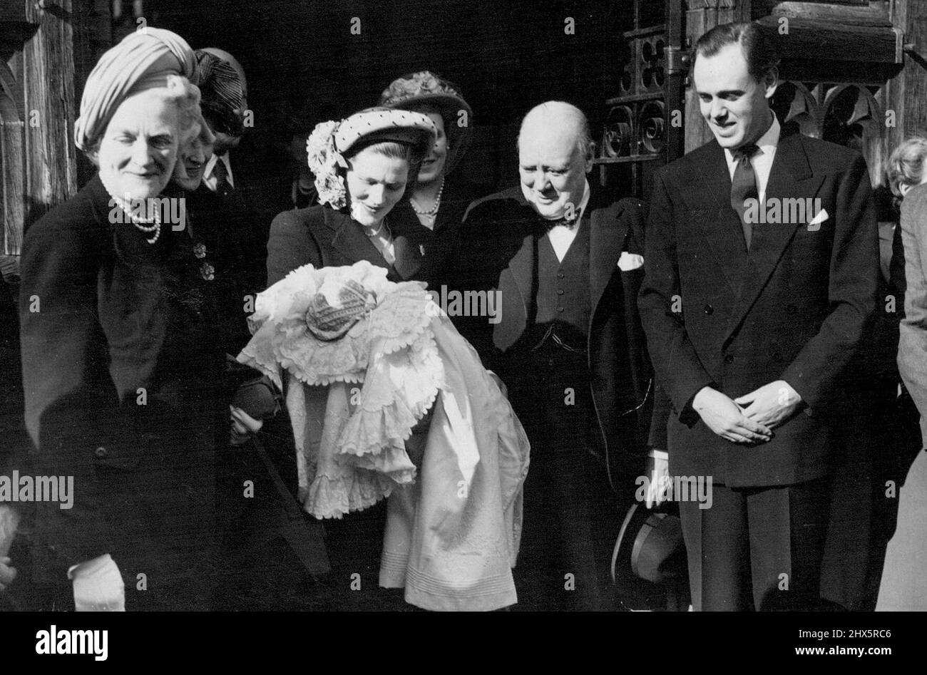 A Famous Grandfather -- Left to right: Mrs. Winston Churchill, Mrs. Soames with the baby, Mr. Winston Churchill, and Mr. Christopher Soames, leaving Westerham Church after the ceremony. The infant son of Mr. Christopher Soames and Mrs. Soames - formerly Miss Mary Churchill daughter of Mr. and Winston Churchill - was christened at Westerham (Kent) Parish Church. The baby was named Arthur Nicholas Winston. March 28, 1948. (Photo by Sport & General Press Agency, Limited). Stock Photo