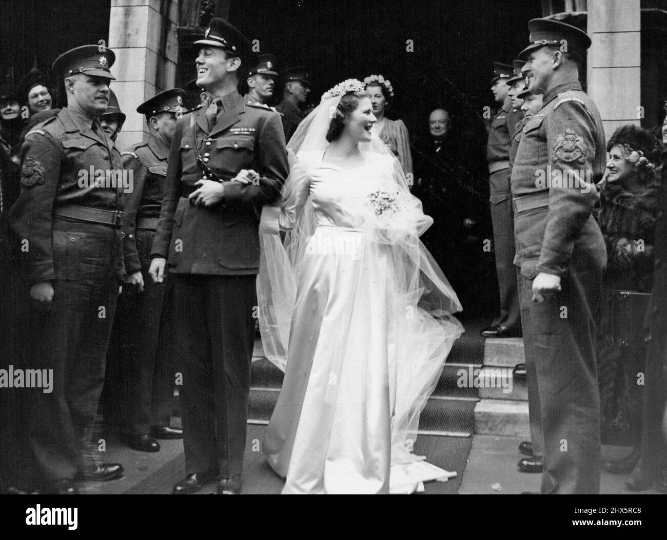 Mary Churchill Weds -- The Bridal couple leaving St. Margaret's Westminster after their wedding this afternoon February 11. Mary Churchill's dress was in white slipper satin with heart-shaped neckline, turn-back cuffs on three-quarter loose sleeves and very full skirt. Bridal Couple Miss Mary Churchill , youngest daughter of Mr. Winston Churchill, leader of the Opposition and Britian's war-time Prime Minister was married to Captain Christopher Soames of the Coldstream Guards, Assistant Military attache at the British Embassy in Paris, in St. Margaret's Westminster, today February 11. February Stock Photo