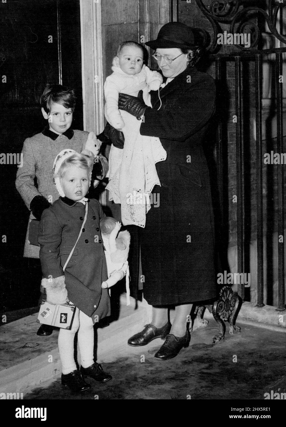 On arrival at No 10 L to R 3 yrs Emma, 4½ yrs Nicholas, with Miss Hilda King their Nannie holding 7 months Jeremy. Mr. Churchill's Grandchildren to-day arrive at no 10 where they will stay while the Churchill's are in America, they are the children of Capt; Soames and Mary. January 1, 1953. (Photo by Daily Mail Contract Picture). Stock Photo