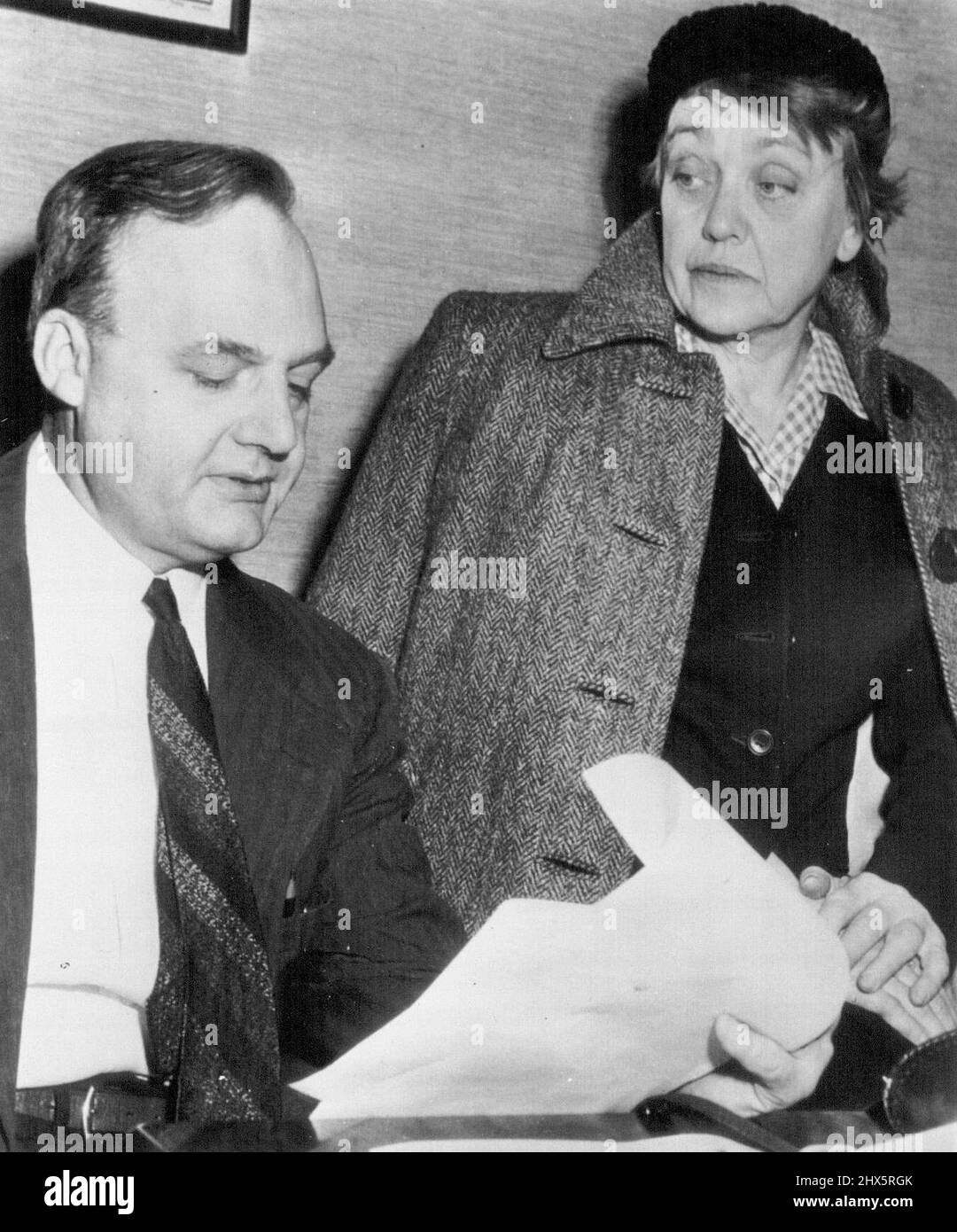 Author Confers With Attorney on Spy Charges - Agnes Smedley, American author, confers with her attorney, O. John Rogge, here today, after the U.S. Army released a report of Russian spy activities in Japan during the war. The report, a copy of which Rogge is reading, links Miss Smedley to the ring as its Shanghai operative, and says she 'is a spy and agent of the Soviet government.' The Army report says the Japanese smashed the ring almost by accident just before the attack on Pearl Harbor in 1941. February 10, 1949. (Photo by AP Wirephoto). Stock Photo