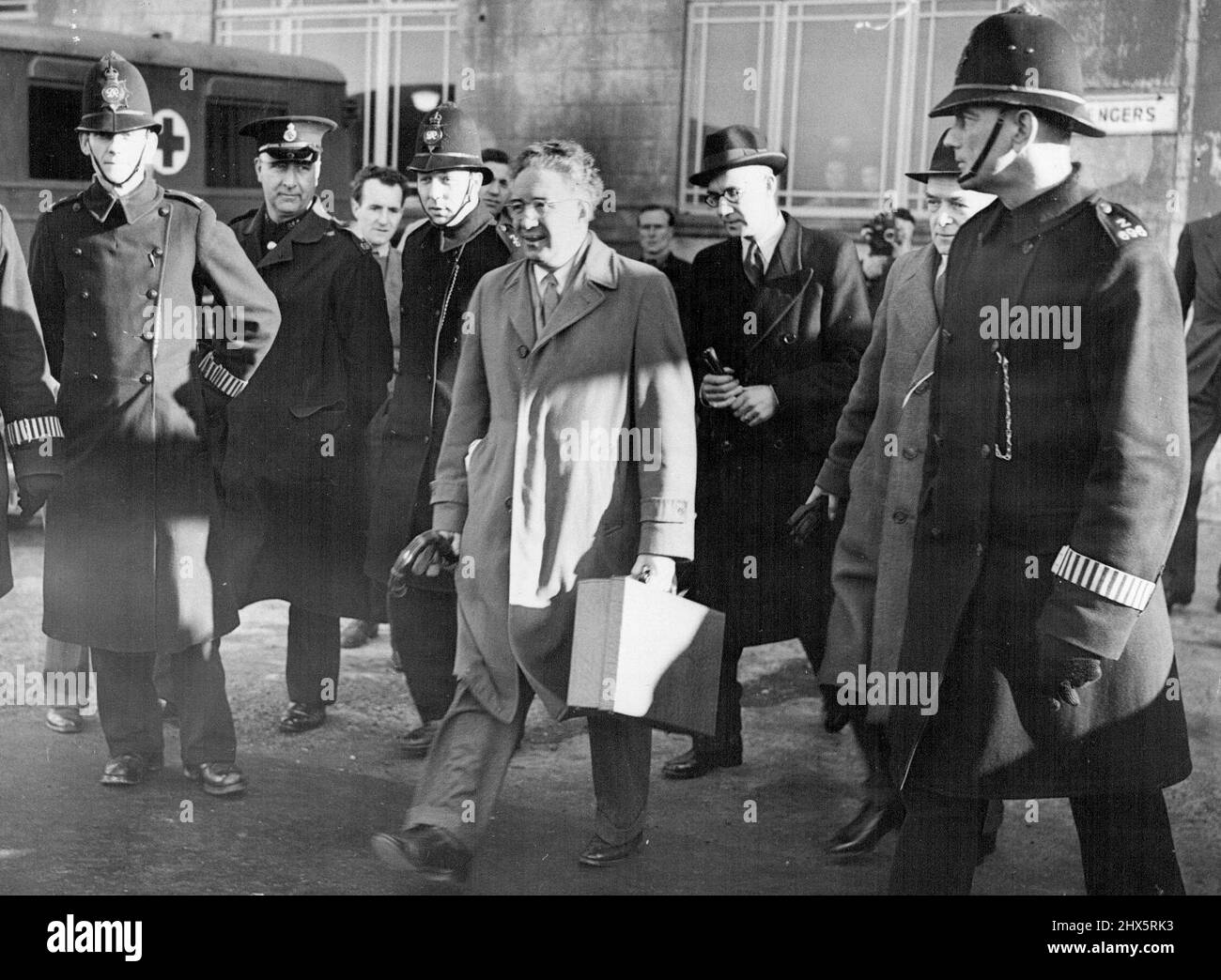 Smertenko Leaves Croydon After Night At Police Station - Professor Smertenko (centre, hatless) escorted to the plane by police as he left Croydon. Having spent the night in Wallington Police Station, Surrey, Professor Johan Smertenko. 50-year-old Vice-President of the American League for a Free Palestine left Croydon Aerodrome, near London, to return to Paris. He flew in the same private-charter French plane in which he had come to Britain in defiance of a Home Office ban on his entry. The ban had been imposed following Smertenko's visit last December, when he had accused Britain of Stock Photo