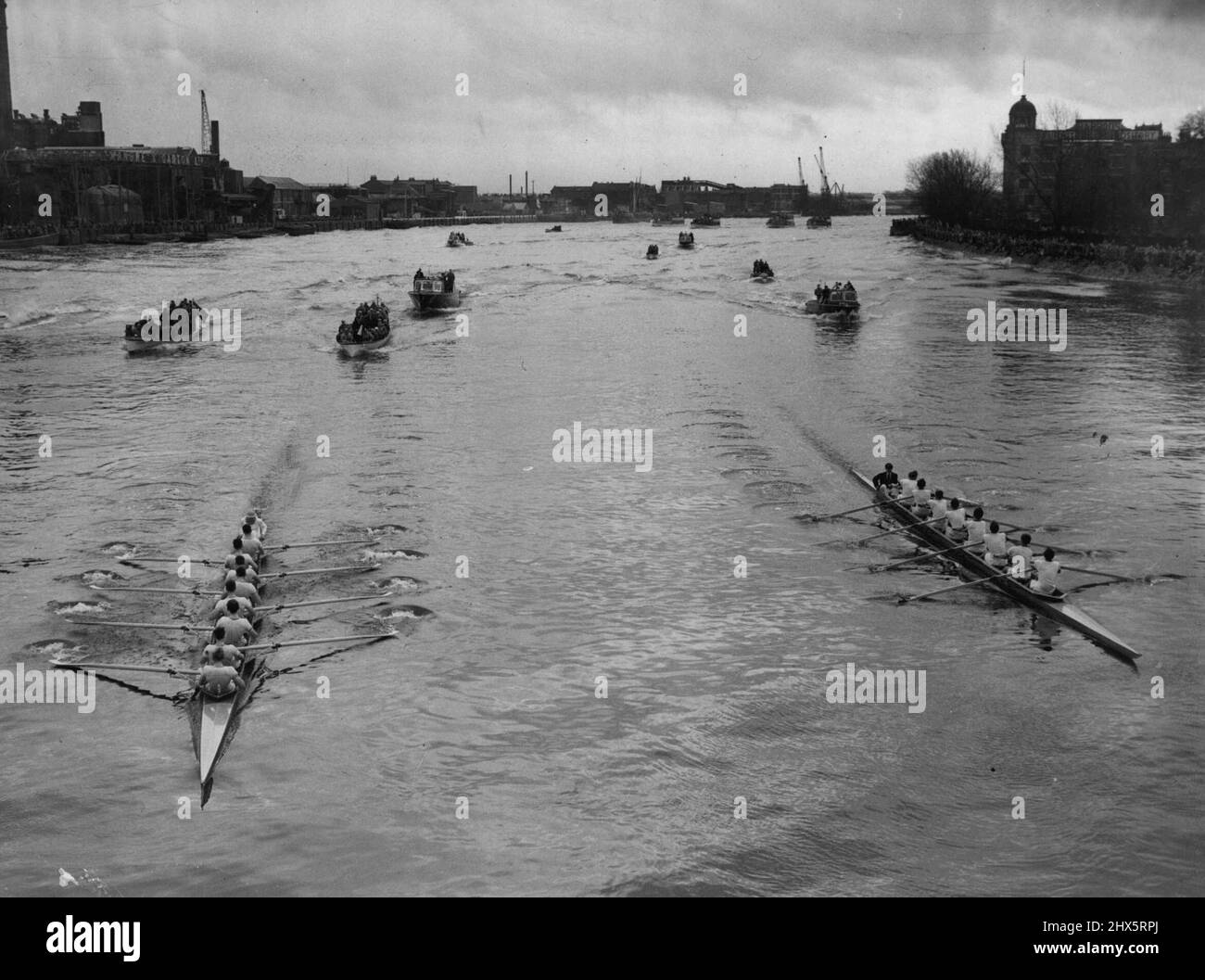 The Boat Race -- Cambridge won the Boat Race today by a margin of about 12 lengths over Oxford. The Crews about to shoot Hammersmith Bridge. This is where Cambridge (left) went into the lead. March 6, 1955. Stock Photo