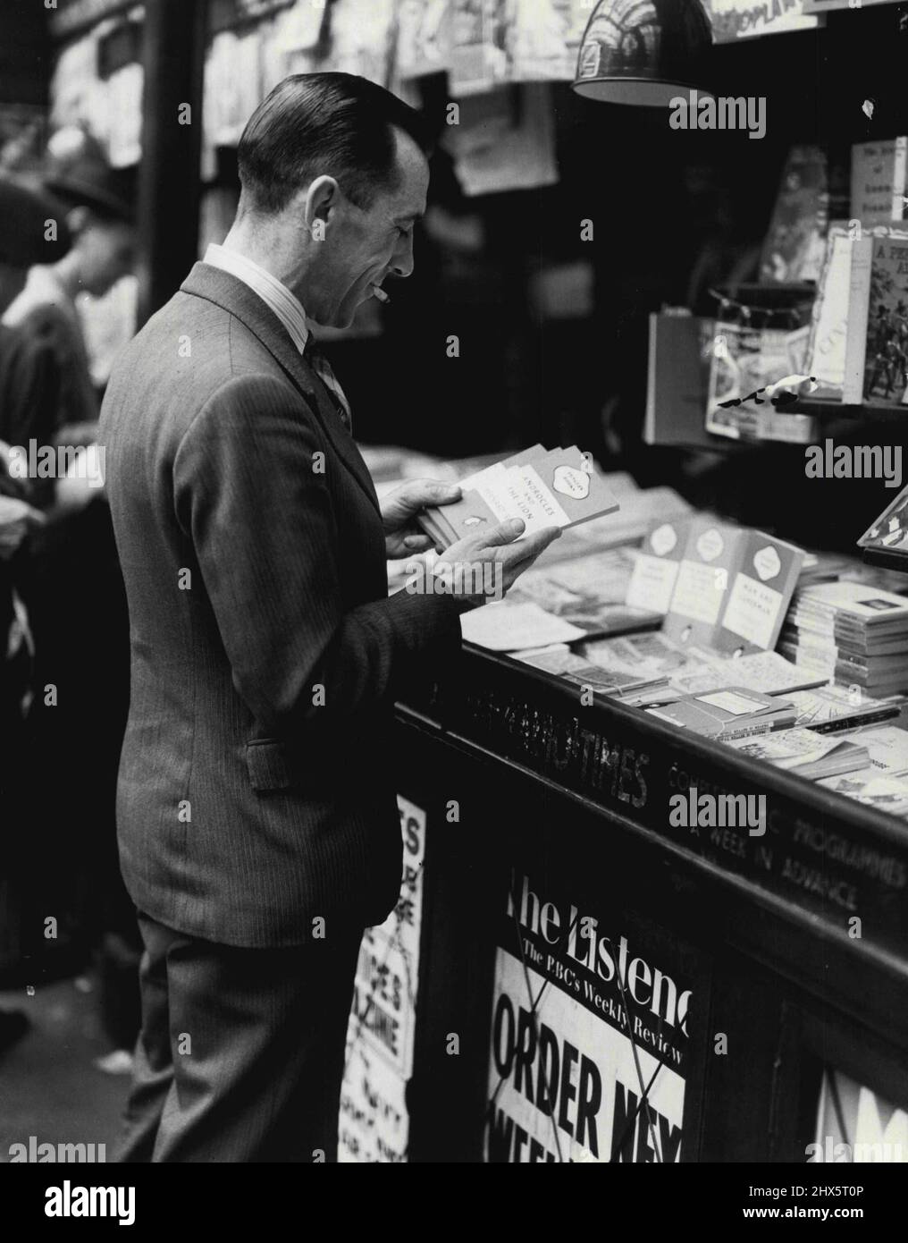 Adventure In Publishing. -- The Penguin reader -- who is he? Not a type, as the devotees of other publishers may be, but just one of the world's reading public. He is buying a Shaw Penguin at Waterloo station. March 1, 1947. (Photo by Pictorial Press). Stock Photo