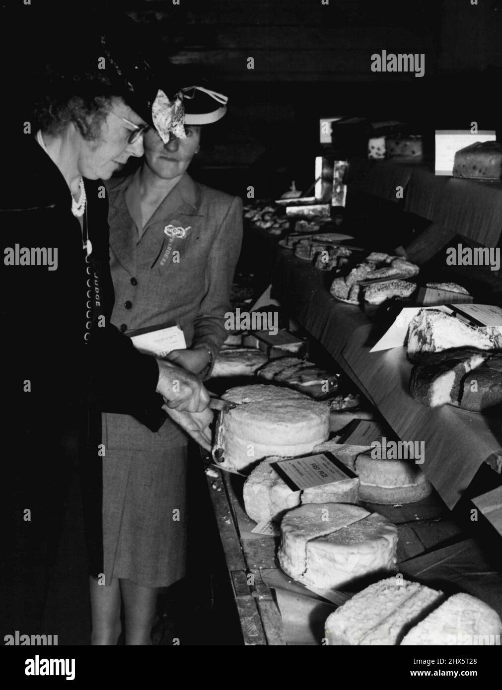 Miss Florrie James, home section judge, cuts the first prize iced rainbow cake. February 28, 1948. Stock Photo