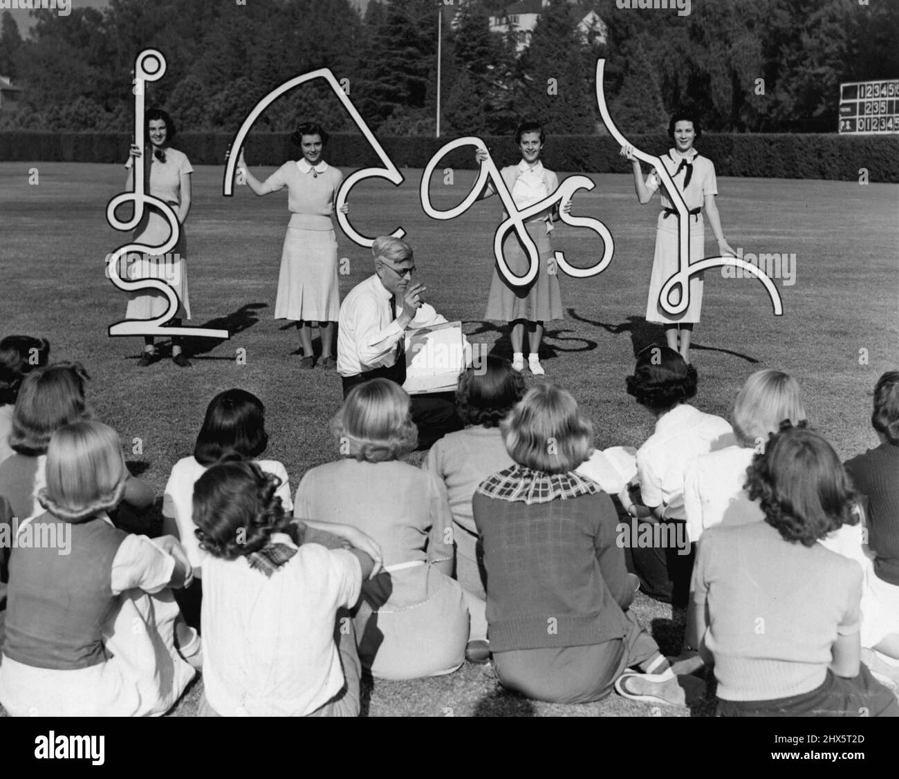 Shortening Shorthand Instruction - Enlarged shorthand characters being 'Flashed' before students of a visual education class on the grounds of the Pasadena, Cal., Junior High School to test the students' memories, after a few seconds of study in a demonstration of a new simplified shorthand method, developed after several years of research. The method is based upon he corresponding letters of Longhand, utilizing only enough of the characters to serve as a memory guide. This visual education is being tried under the direction of the Pasadena Educational Research Association. July 07, 1949. Stock Photo