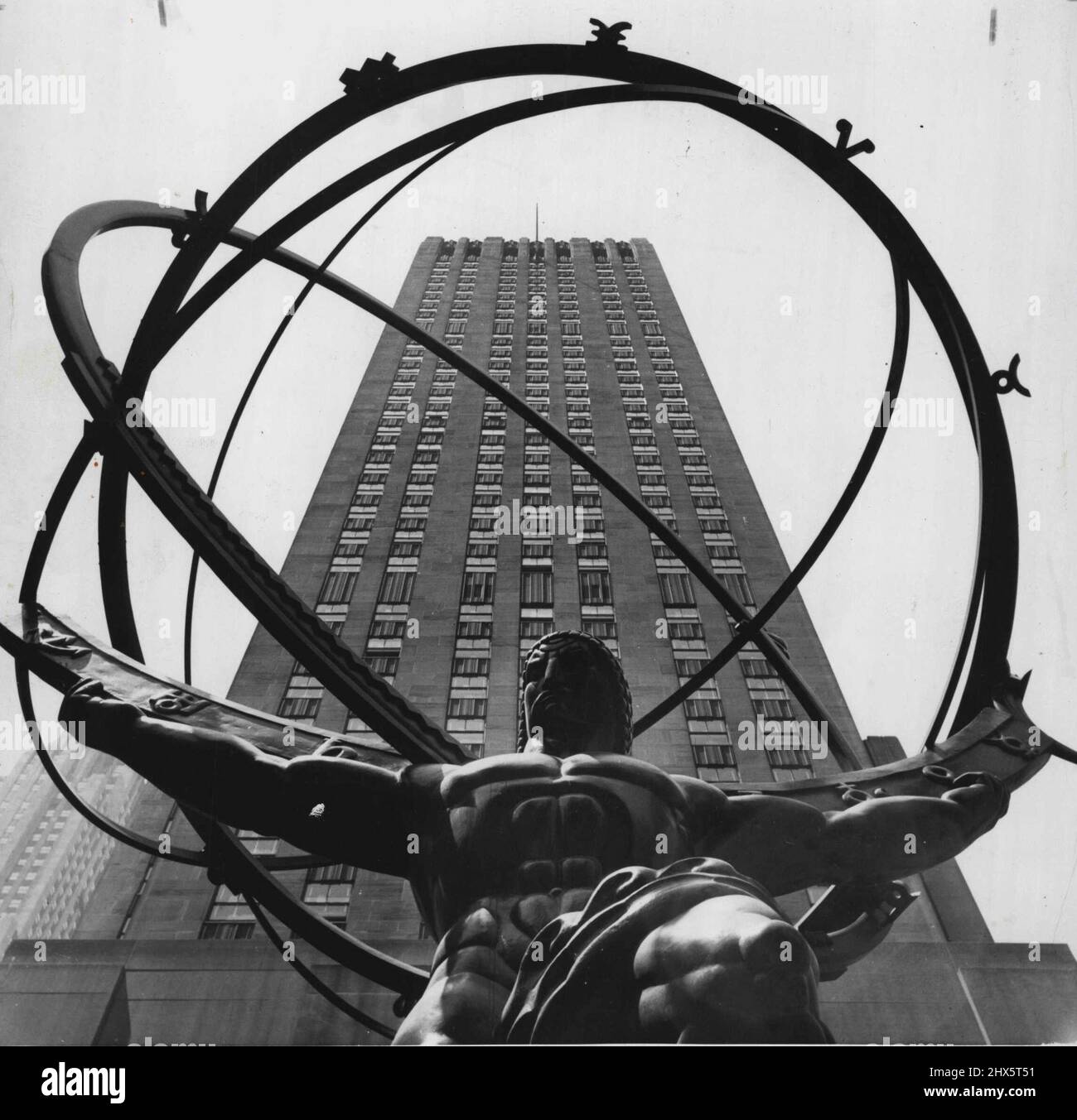 Shooting Spree (First Of Twelve) -- One of the towering structures of Rockefeller Center looms behind this statue of mighty Atlas, a favorite target for visiting amateur cameramen. Easily one of the most photographed landmarks in Manhattan, the bronze burden of having to contend with shutterbugs who swarm over the area each day. July 15, 1955. (Photo by United Press). Stock Photo