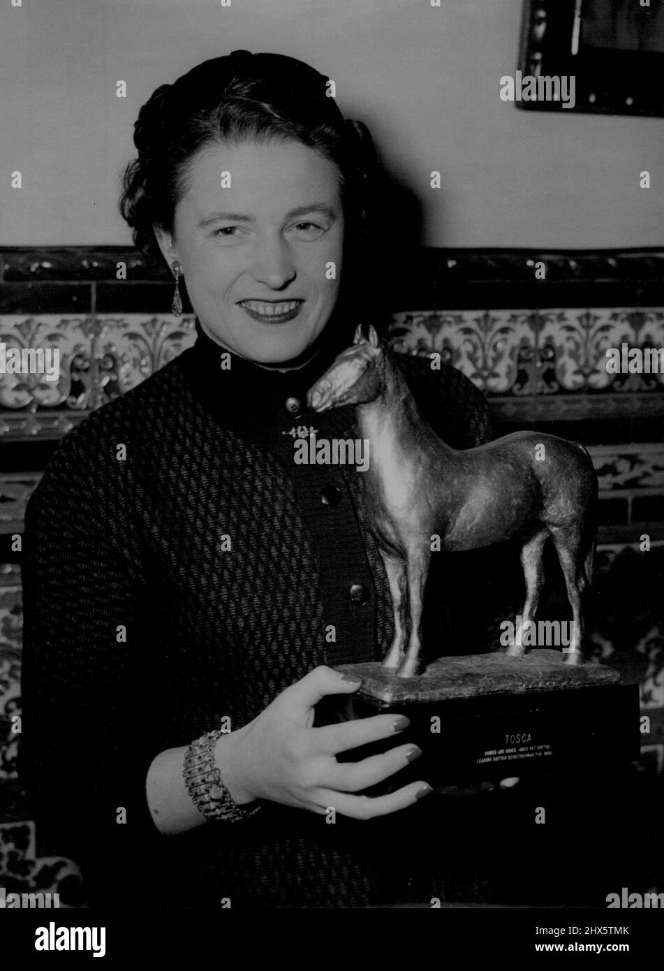 A Tosca For Pat -- Miss. Pat Symthe with her *****. Show jumping champion Miss. Pat Smythe was the guest of honour at Luncheon at the Spanish Restaurant in London's West End, given by the directors of Cassell & Co., who this Autumn published her book 'Jump for Joy'. The purpose of the function was to present Pat with - statuette of her horse 'Tosca' 30, while film stars strive for their Oscar, this British idol is more than content with a Tosca! December 14, 1954. (Photo by Reuterphoto). Stock Photo