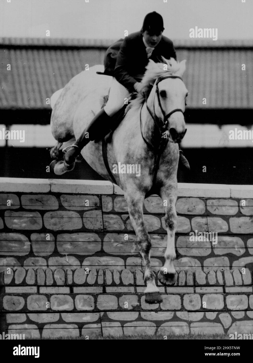 International Partnership -- Pat Smythe riding Tosca takes the wall jump in the London Trial Stakes, one of the opening events of the International Horse Show at White City Stadium, London to-day (Monday). July 18, 1955. (Photo by Reuter Photo). Stock Photo