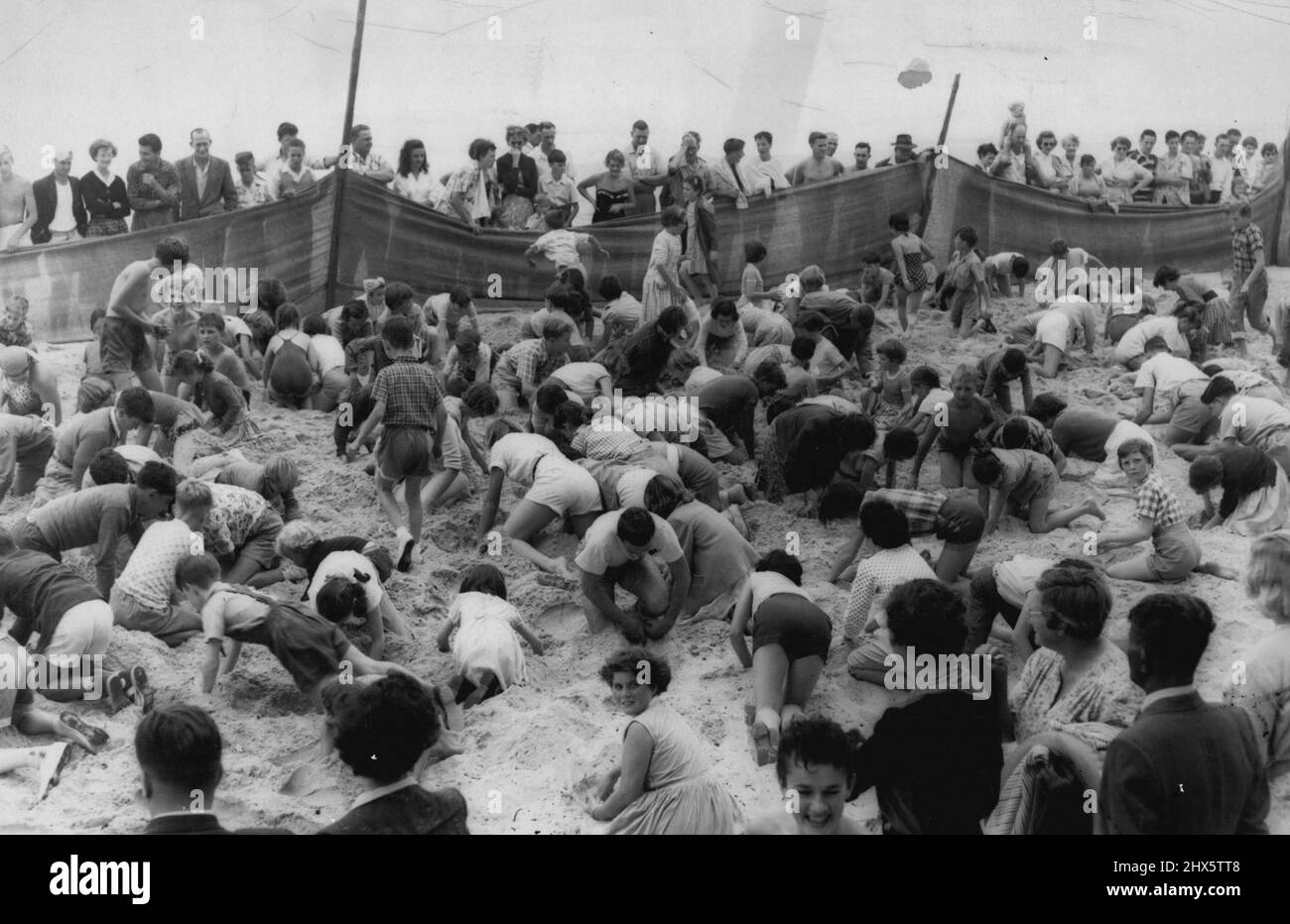 A few of the 1000 odd youngsters who took part in the search, busily 'prospecting'. All the world loves a treasure hunt and Manly youngsters are no exception. When a local store hid £20 worth of prizes on Manly Beach it was a case of heads down and dig. December 12, 1955. Stock Photo